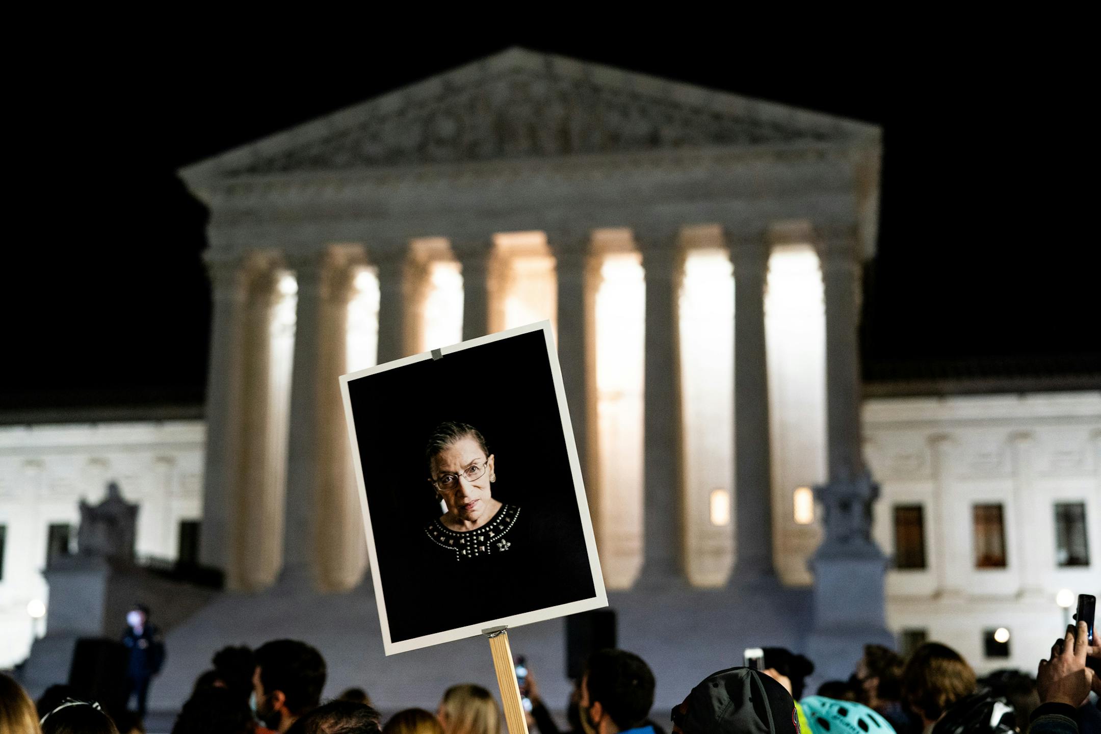 A person holds a sign with a photo of the late Justice Ruth Bader Ginsburg at a vigil in her honor outside the Supreme Court in Washington, Sept. 19, 2020. (Anna Moneymaker/The New York Times)