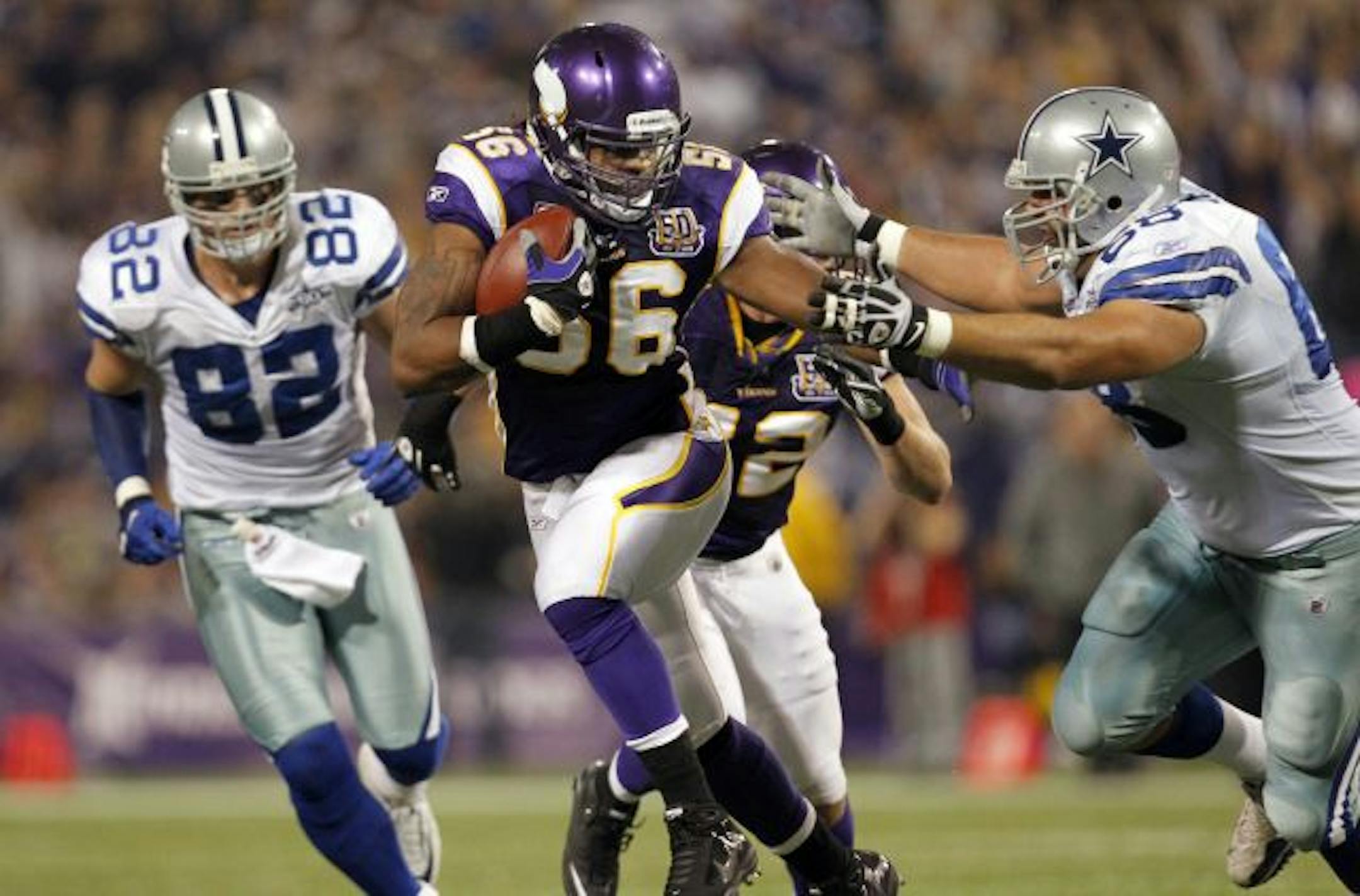 Vikings linebacker E.J. Henderson (56) ran after intercepting a Tony Romo pass in the first quarter.