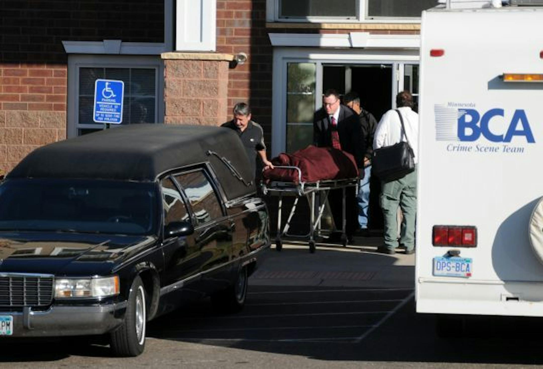 One of the 3 victims of a triple homicide is loaded into a hearse at the Willow Ridge Apartments in Vadnais Heights on Thursday, Oct. 14, 2010.