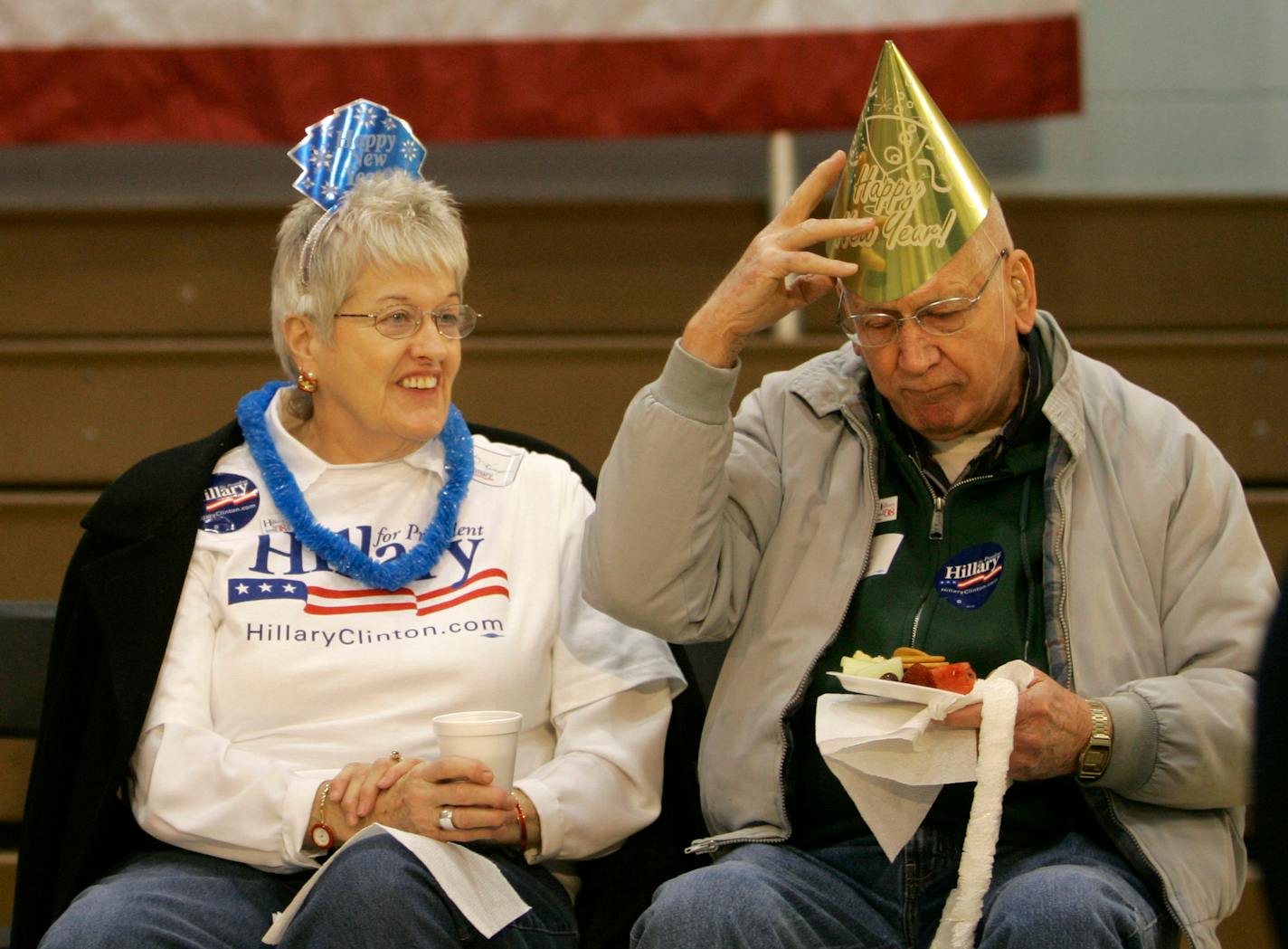 Judy and Ed Kemper donned new year's hats provided by organizers of a campaign stop for Hillary Rodham Clinton on Monday at Muscatine West Middle School in Muscatine, Iowa.