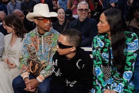 Pharrell Williams, from left, Rocket Williams and Helen Lasichanh attend the the Kenzo Spring Summer 2025 collection, that was presented in Paris, Fra