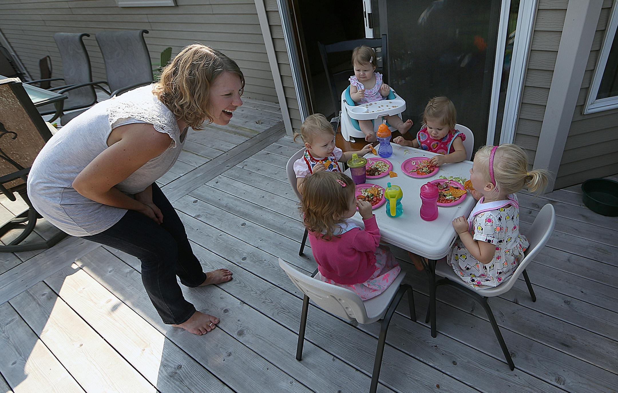 Children sat at a small table for lunch outside on a deck during the playdate (parent is Amy Korkki).