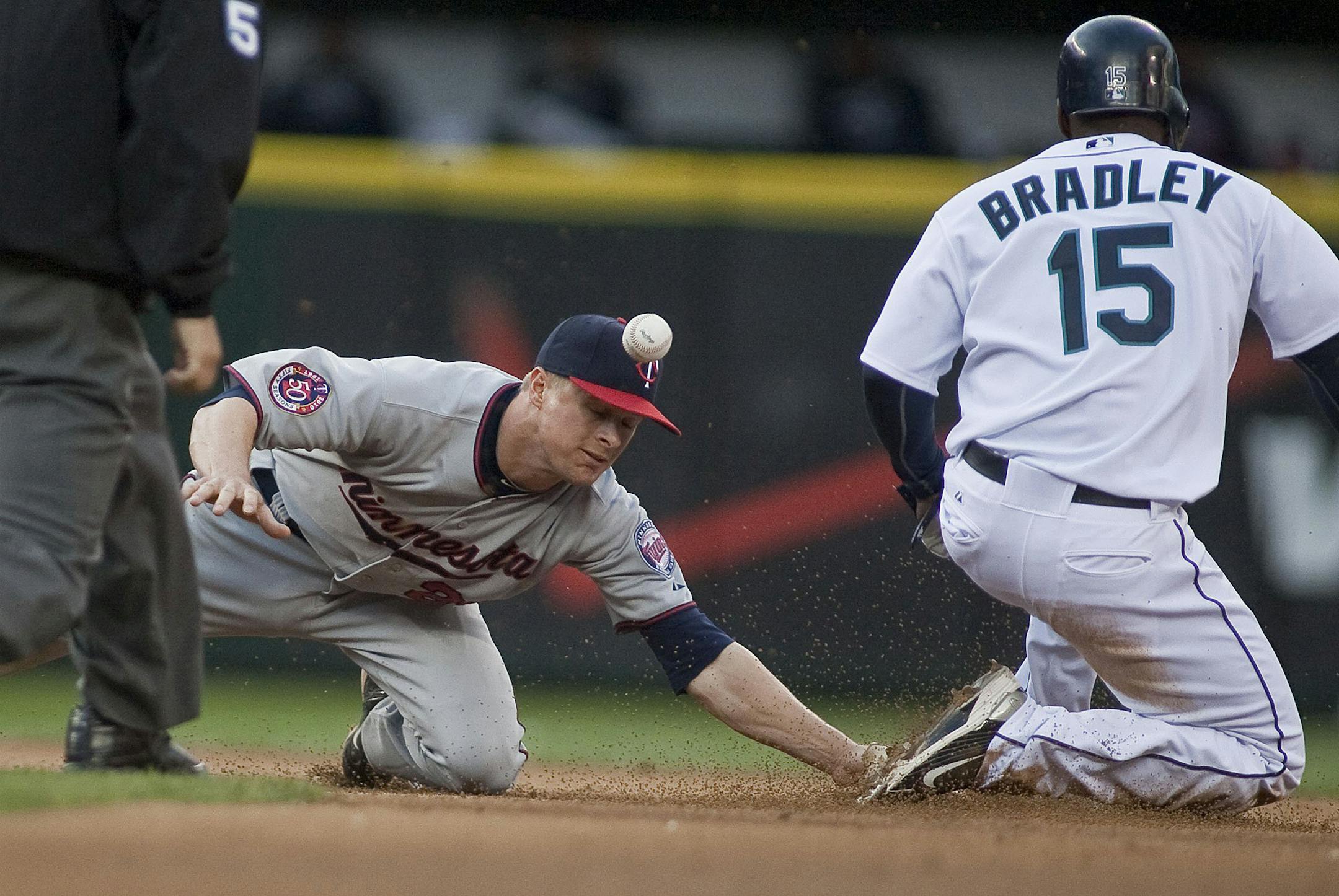 Minnesota Twins second baseman Matt Tolbert watches the ball pop out of his glove as Seattle Mariners' Milton Bradley (15) successfully steals second in the fifth inning at Safeco Field in Seattle, Washington, on Wednesday, June 2, 2010.