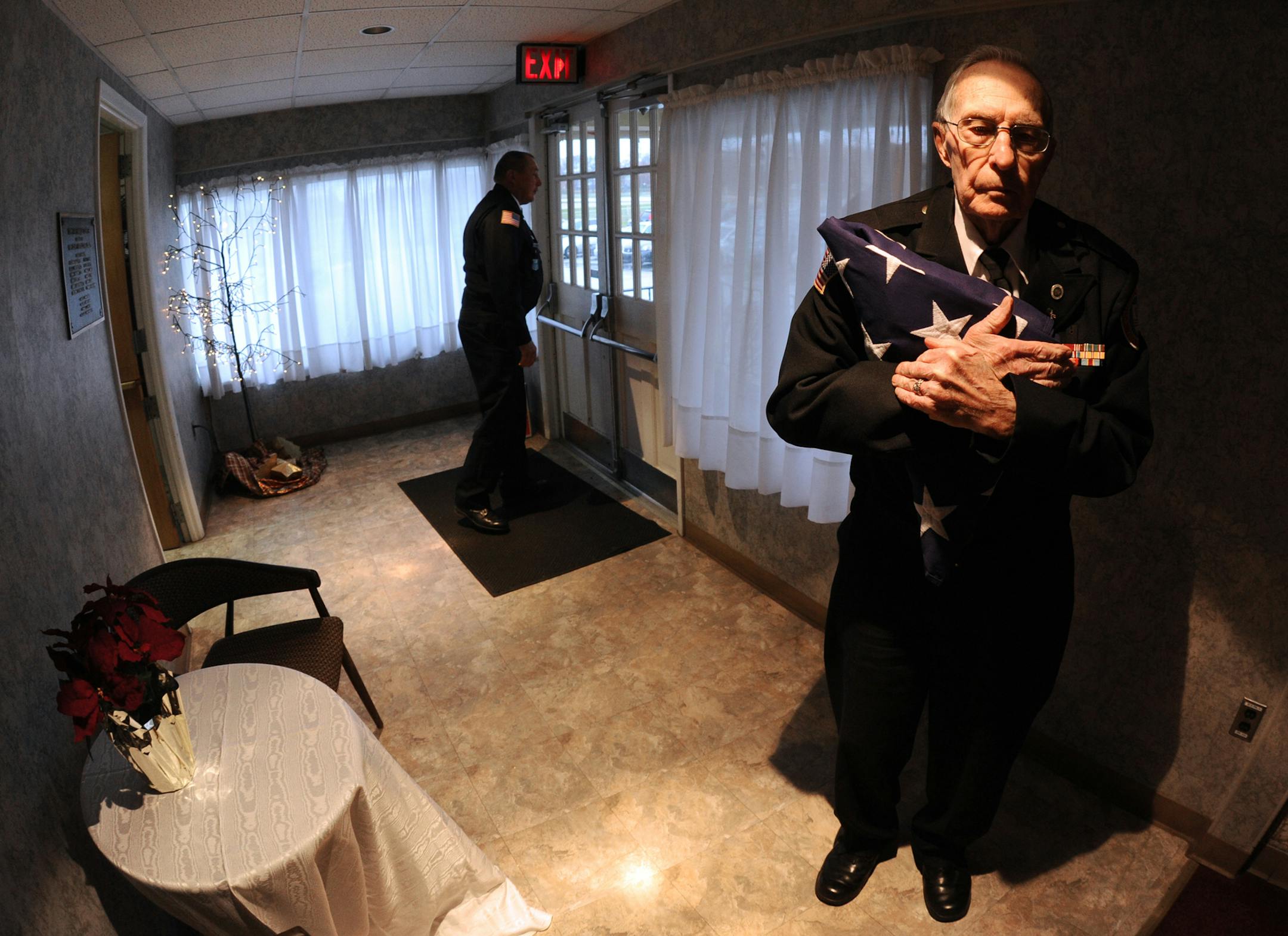 Dick Frantz, a member of the York County Veterans Honor Guard, holds onto the flag used for the folding ceremony during the Pearl Harbor/Battle of the Bulge remembrance ceremony in the White Rose Room at the York Expo Center in York, Pa., Friday, Dec. 6, 2013. (AP Photo/York Daily Record, Jason Plotkin) YORK DISPATCH OUT