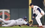 Seattle Mariners' Mitch Haniger, left, beats the throw to Minnesota Twins first baseman Logan Morrison in a pickoff attempt in the first inning of a m