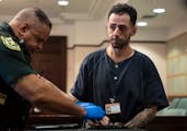 Ehsan Karam glanced at victim Holly Appell as he was fingerprinted after he was sentenced to two years in jail at the Orange County Courthouse on Thur