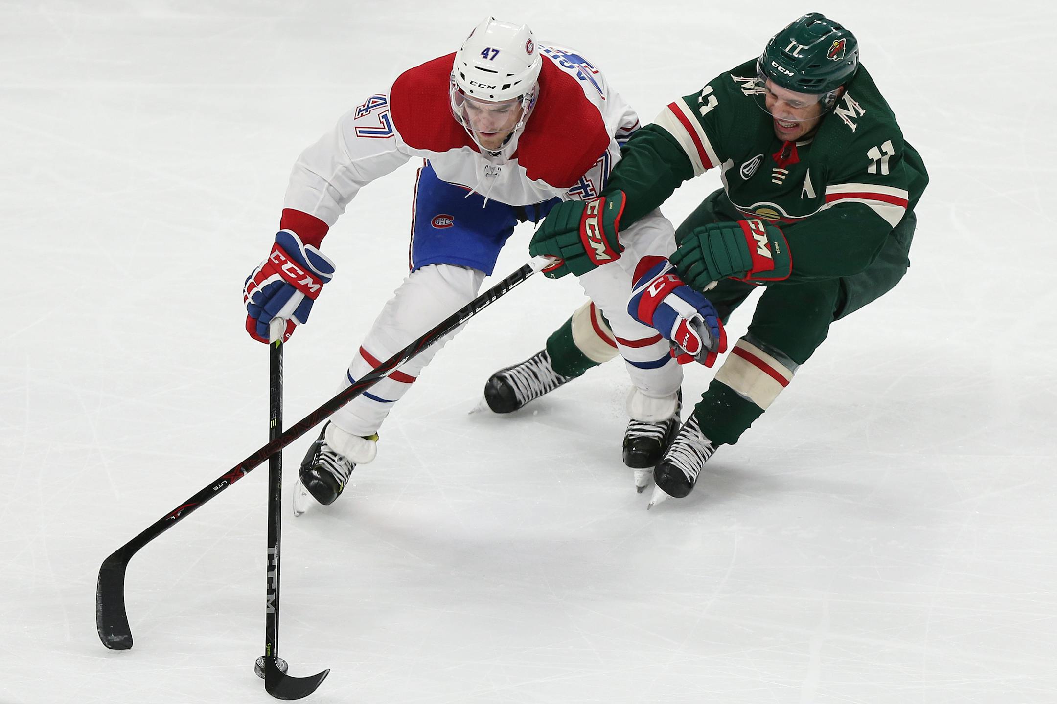 The Wild's Zach Parise fought for possession of the puck against the Canadiens' Kenny Agostino in the third period Tuesday.