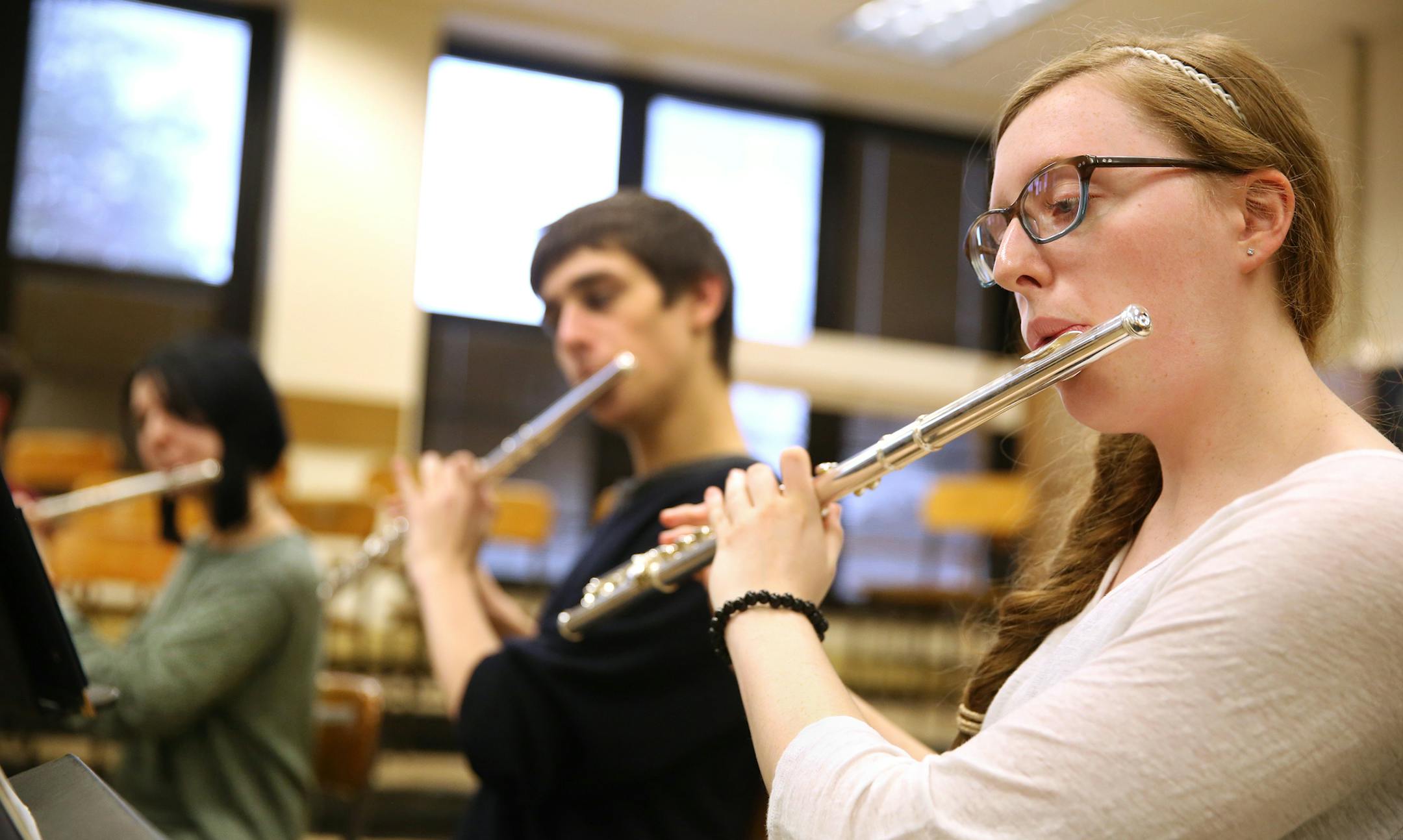 Sophia Pellar, 16, plays the flute during a varsity wind ensemble practice at New Trier High School in Winnetka, Ill., on Thursday, April 9, 2015. Pellar wears special ear plugs to help prevent the ear pain she often experiences when playing with the pep band. (Chris Sweda/Chicago Tribune/TNS)