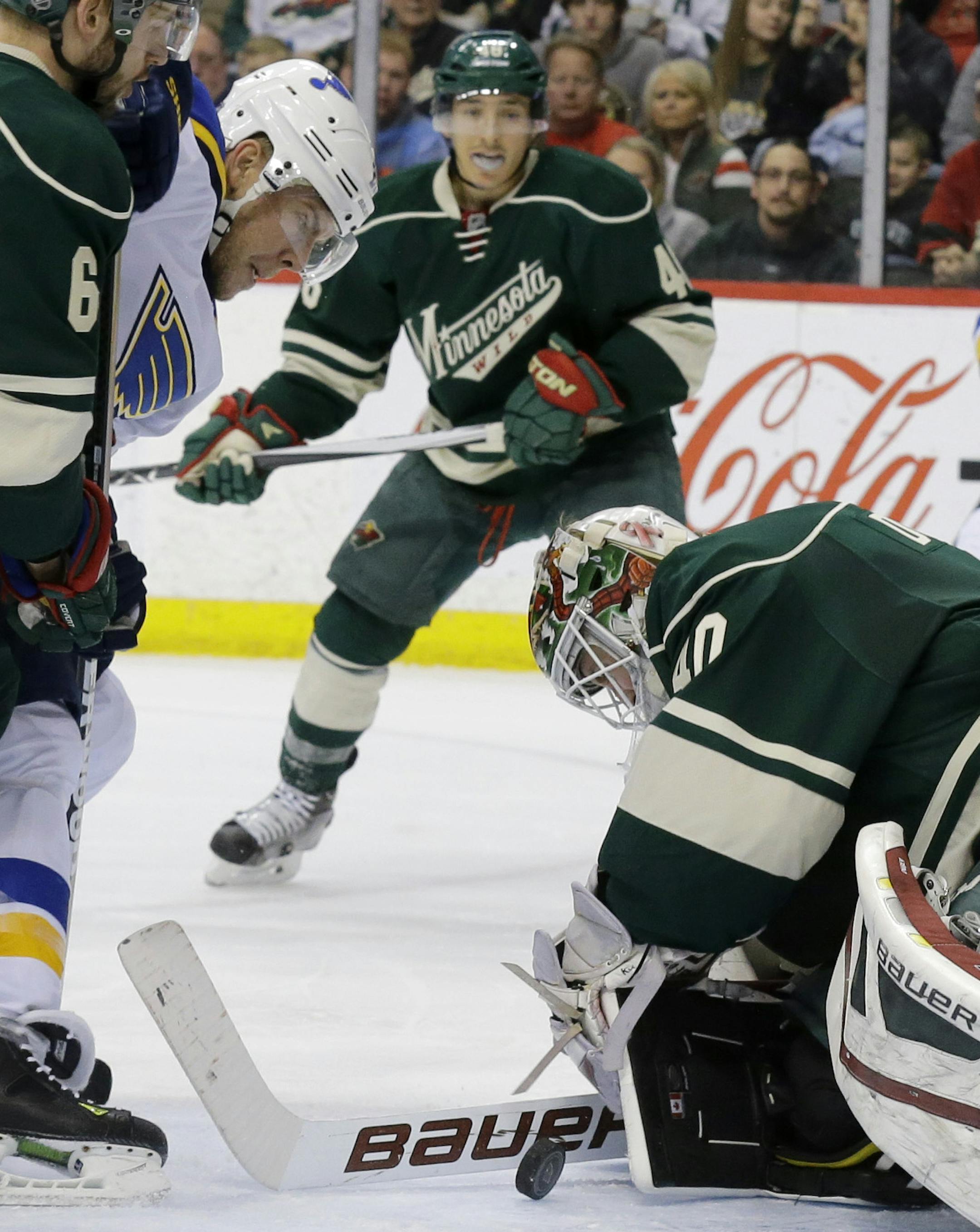 Minnesota Wild goalie Devan Dubnyk, right, deflects a shot by St. Louis Blues center Paul Stastny, center, as Wild defenseman Marco Scandella, left, covers Stastny during the second period of an NHL hockey game in St. Paul, Minn., Saturday, March 21, 2015. (AP Photo/Ann Heisenfelt)