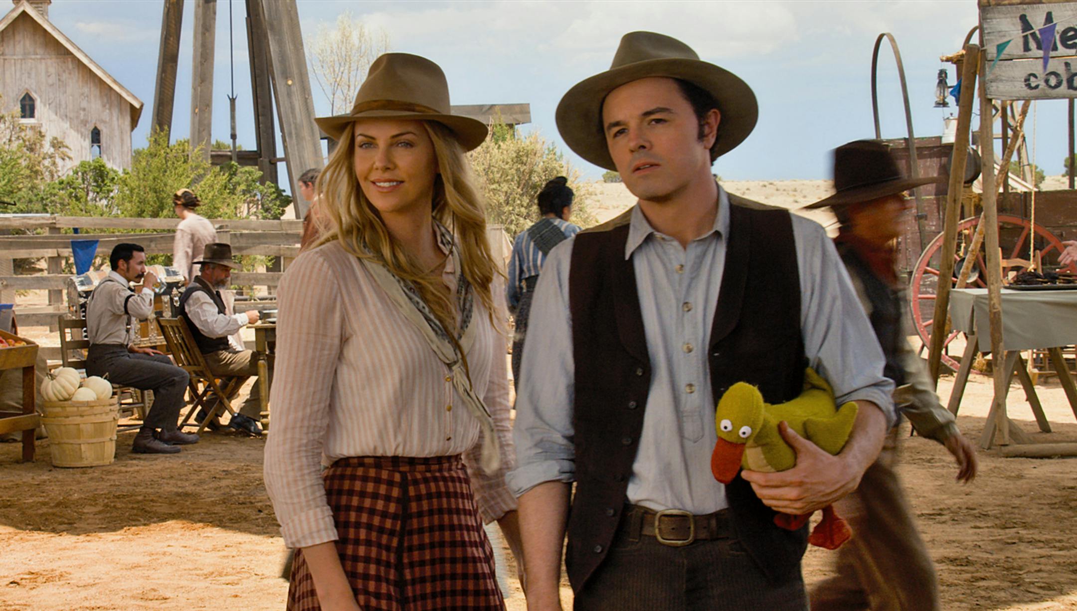 Anna (CHARLIZE THERON) and Albert (SETH MACFARLANE) try not to die at the fair in "A Million Ways to Die in the West", the new comedy from director, producer and co-writer MacFarlane, who plays a formerly cowardly sheep farmer who must put his newfound courage to the test. Photo Credit: Universal Pictures Copyright: ¬© 2014 Universal Studios. ALL RIGHTS RESERVED.