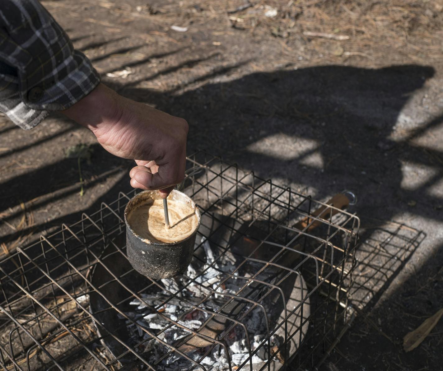 A man who didn't want his name used made coffee at the St. Paul homeless camp. Officials have no plans to break up the site.