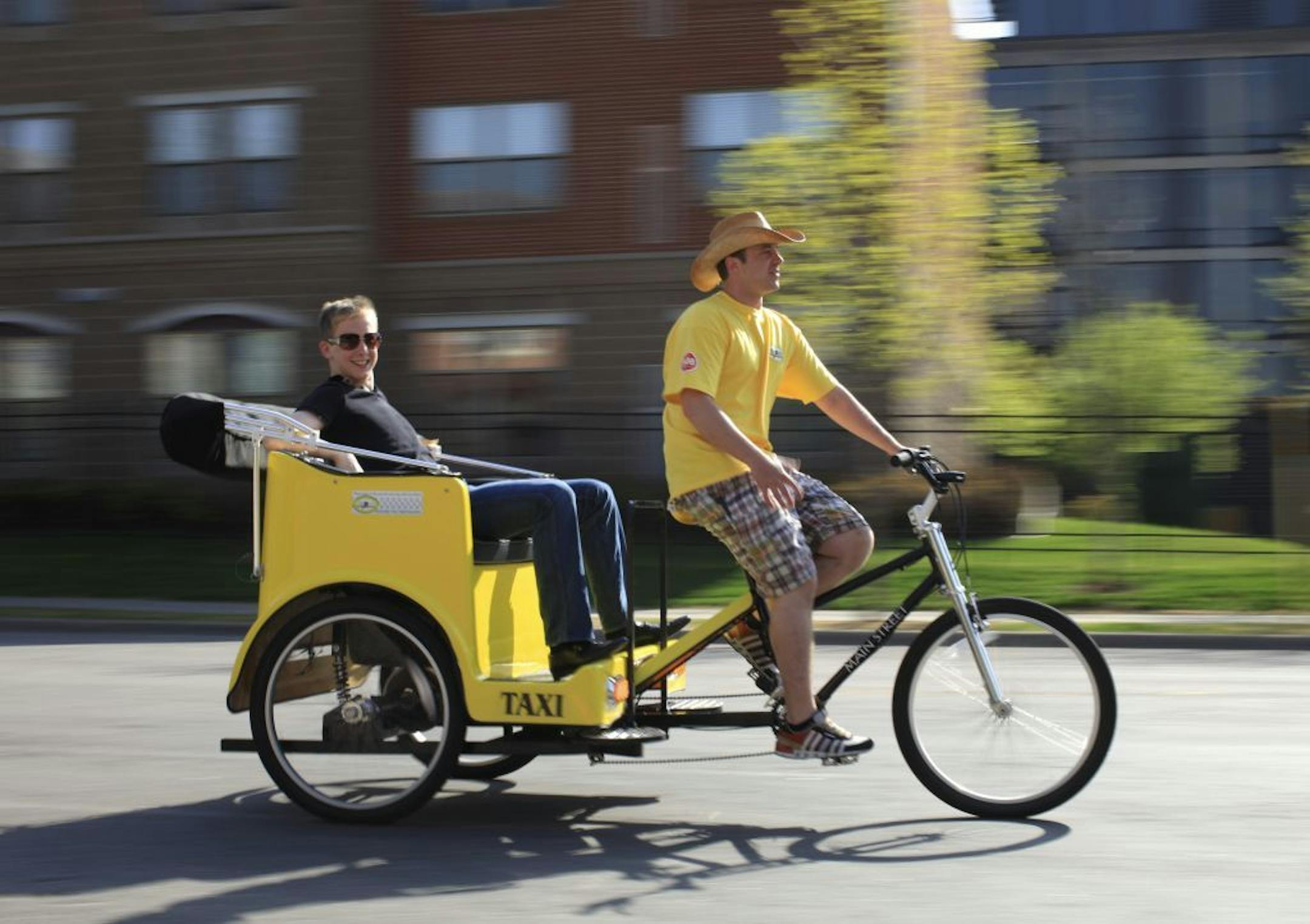Colin McCarty in one of his pedicabs, driven by one of his contractors, J.P. Waterman, Tuesday afternoon on 2nd St. N. in Minneapolis.
