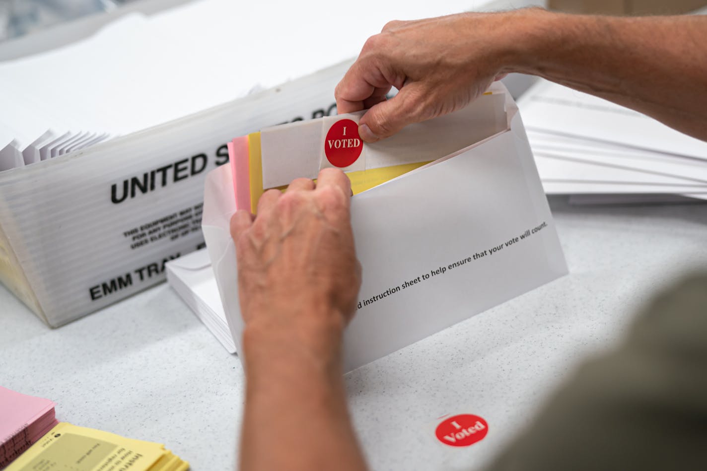 Minneapolis Elections and Voter Services staff prepared mail-in ballot envelopes, including an "I voted" sticker. Because of COVID-19, Minnesota is waiving the requirement to have a witness sign mail-in ballots.