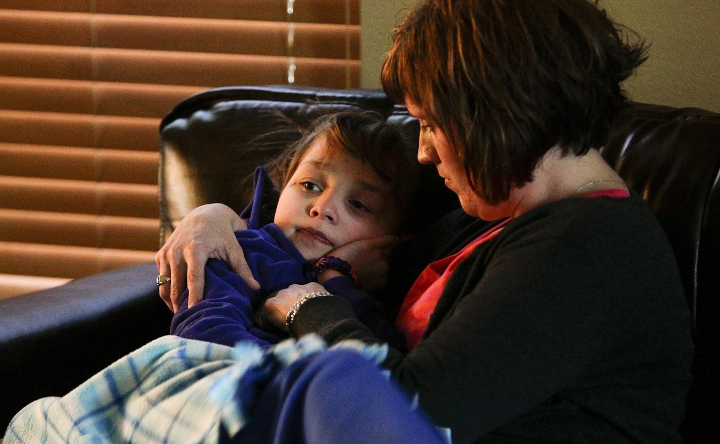 Maria Botker, 38, CNS, RN, holds her daughter Greta, 7, after having a seizure at their home in Colorado Saturday January 18, 2014. Maria moved with her daughter Greta, 7, from Minnesota to take advantage of Colorado's legalization of marijuana so that she can help Greta with her seizures. She uses a liquid medicine called Charlotte's Web which is 30:1 Cannabidiol to THC. "Right now I'm Sacrificing time with them for the hope of a miracle with her," says Botker. Before giving Greta the Charlotte