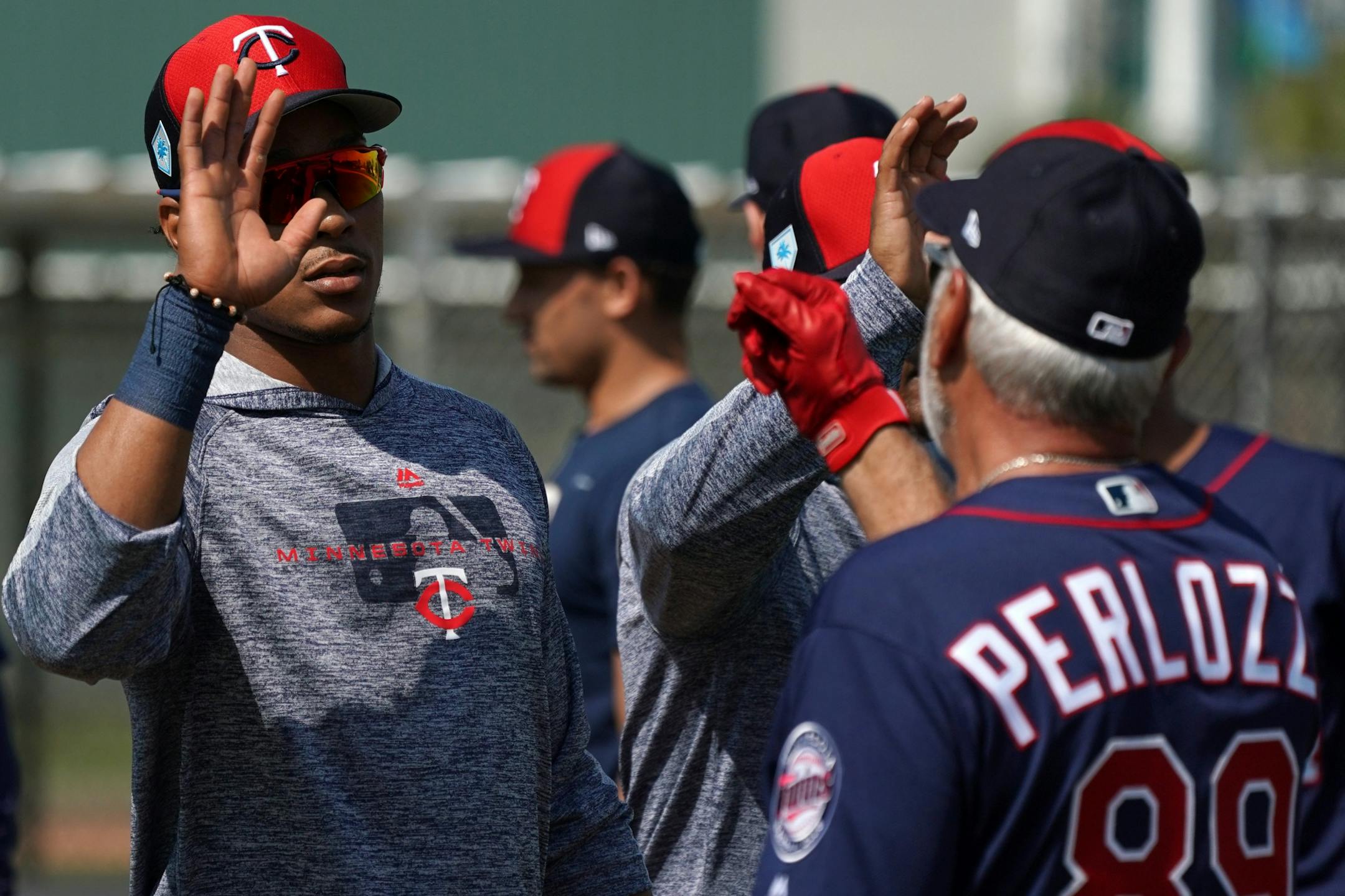 Minnesota Twins shortstop Jorge Polanco (11) high fived with infield coordinator Sam Perlozzo after informal drills Saturday.