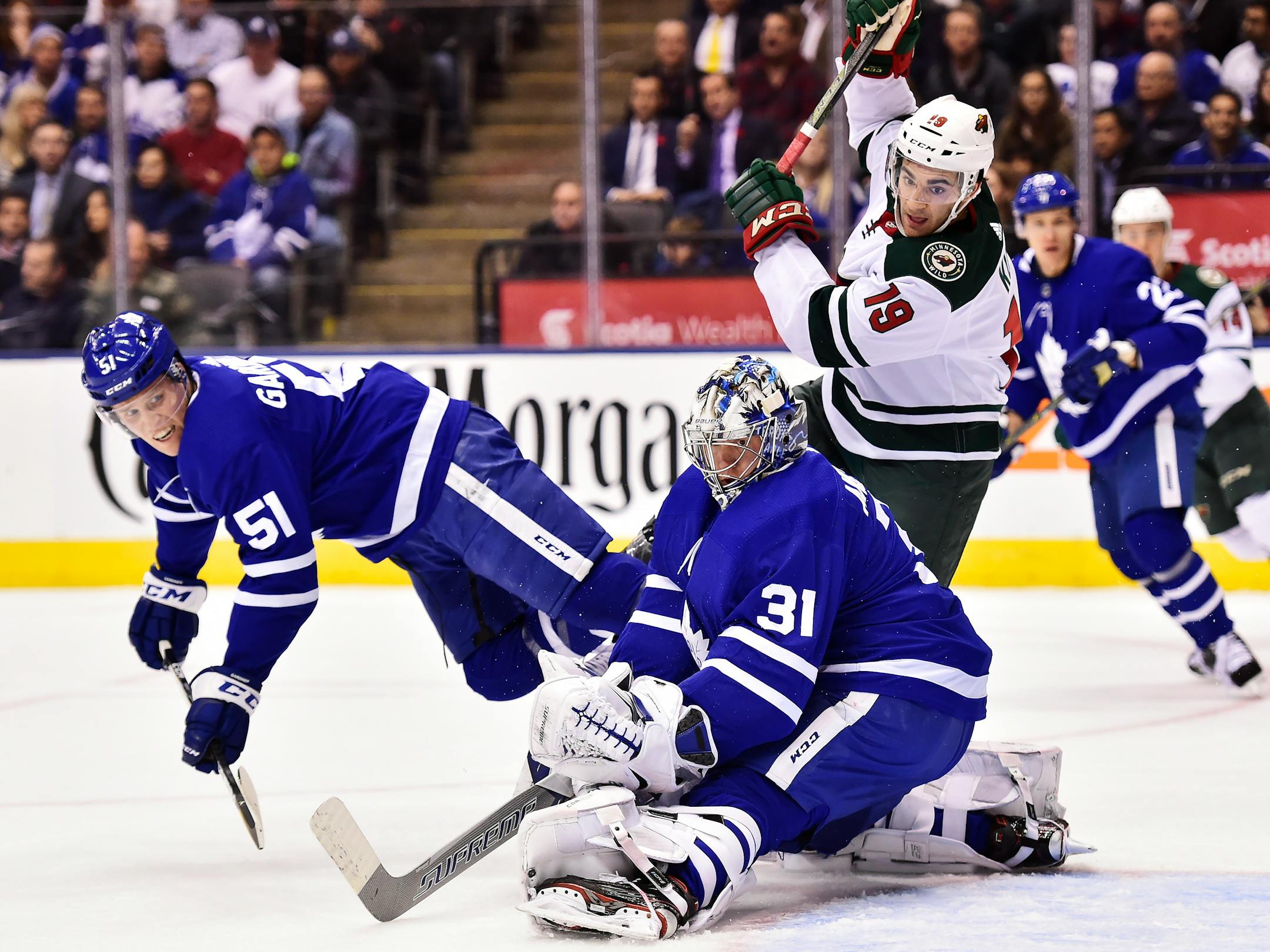 Toronto Maple Leafs goalie Frederik Andersen (31) and defenseman Jake Gardiner (51) and Minnesota Wild center Luke Kunin (19) watch as the puck goes wide of the net during the first period of an NHL hockey game Wednesday, Nov. 8, 2017, in Toronto. (Frank Gunn/The Canadian Press via AP)