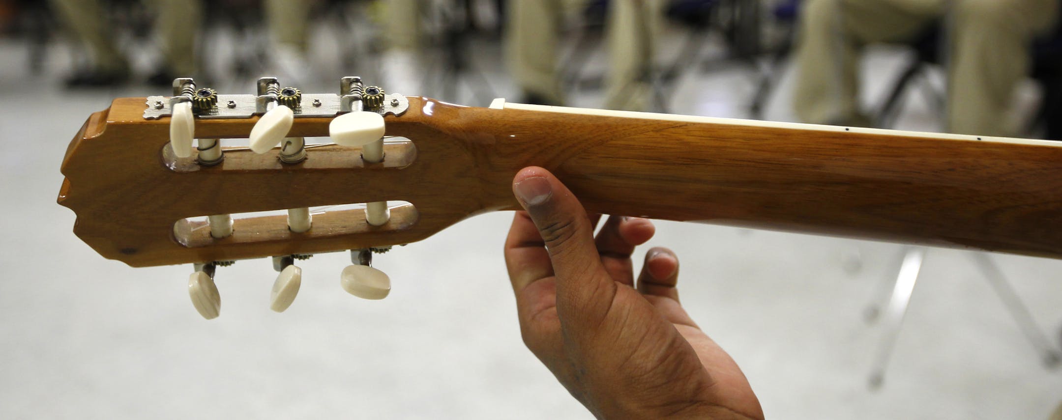 A juvenile offender finds a chord on the neck of the guitar as others practice in a room Tuesday, Aug. 27, 2013 at the Evins Regional Juvenile Center in Edinburg, Texas. For the past several weeks the Hermes Music Foundation has given guitar lessons at the center twice a week to a small group of juvenile offenders. (AP Photo/The Monitor, Nathan Lambrecht) ORG XMIT: MIN2013100318233272