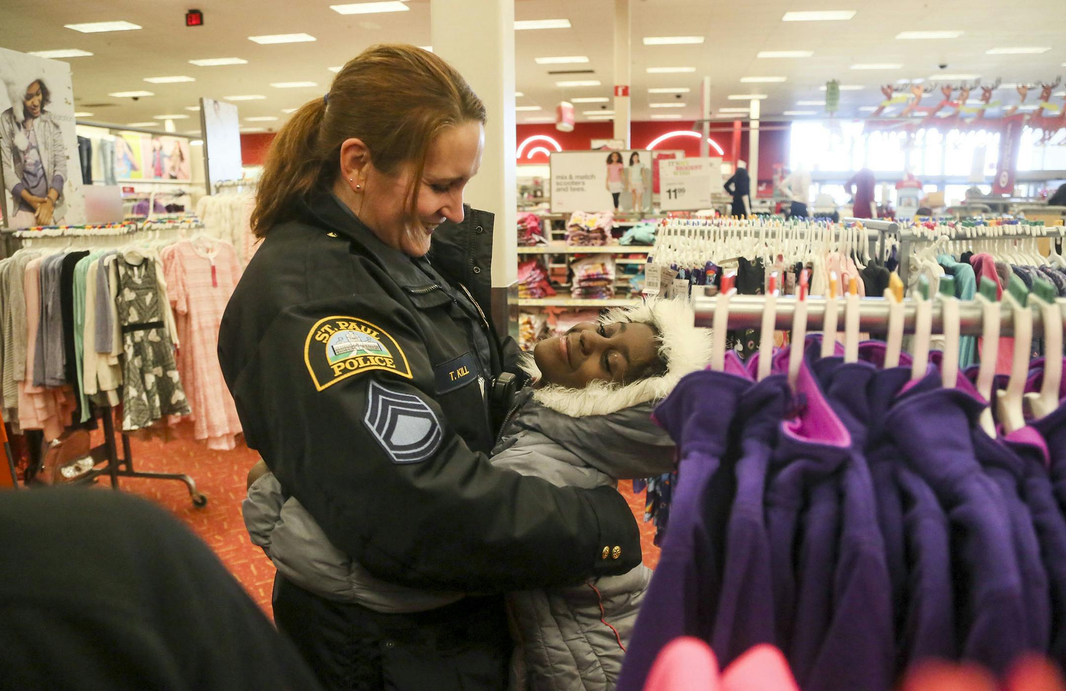 About 280 kids participated in the 14th annual Shop with Cops event where the kids bought Christmas presents for family members with donated money at the Target Superstore Saturday, Dec. 6, 2014, on W. University Ave. in St. Paul, MN. One hundred and fifty St. Paul police officers, metro law enforcement officers and others volunteered their time to assist the kids. Here, St. Paul Police Sgt. Tina Kill hugs Laquiesha Hunter, 8, who Kill ran into in the kids clothing aisle at Target. During last y