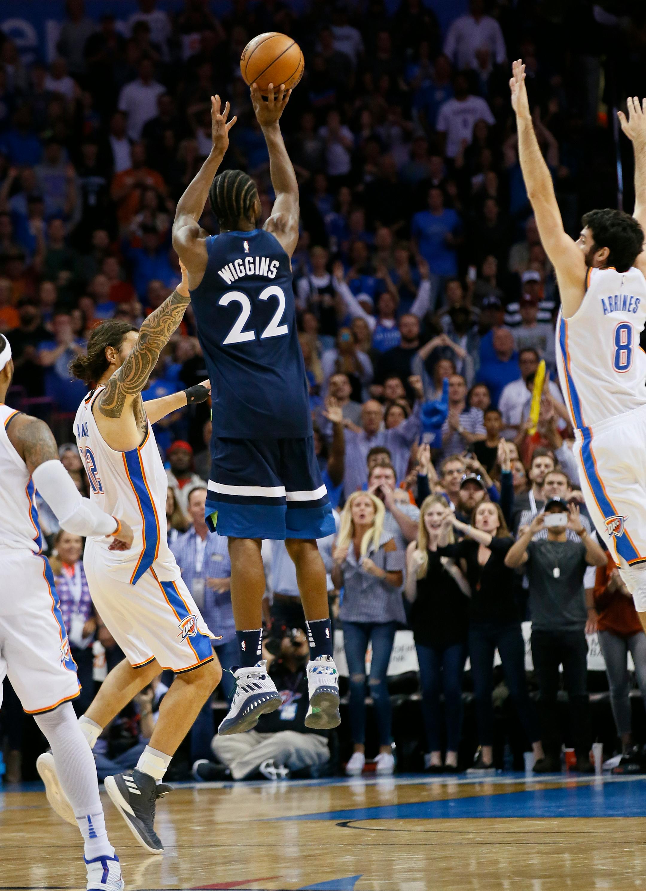 Minnesota Timberwolves guard Andrew Wiggins (22) shoots the game winning shot between Oklahoma City Thunder center Steven Adams (12) and guard Alex Abrines (8) in the fourth quarter of an NBA basketball game in Oklahoma City, Sunday, Oct. 22, 2017. Minnesota won 115-113.