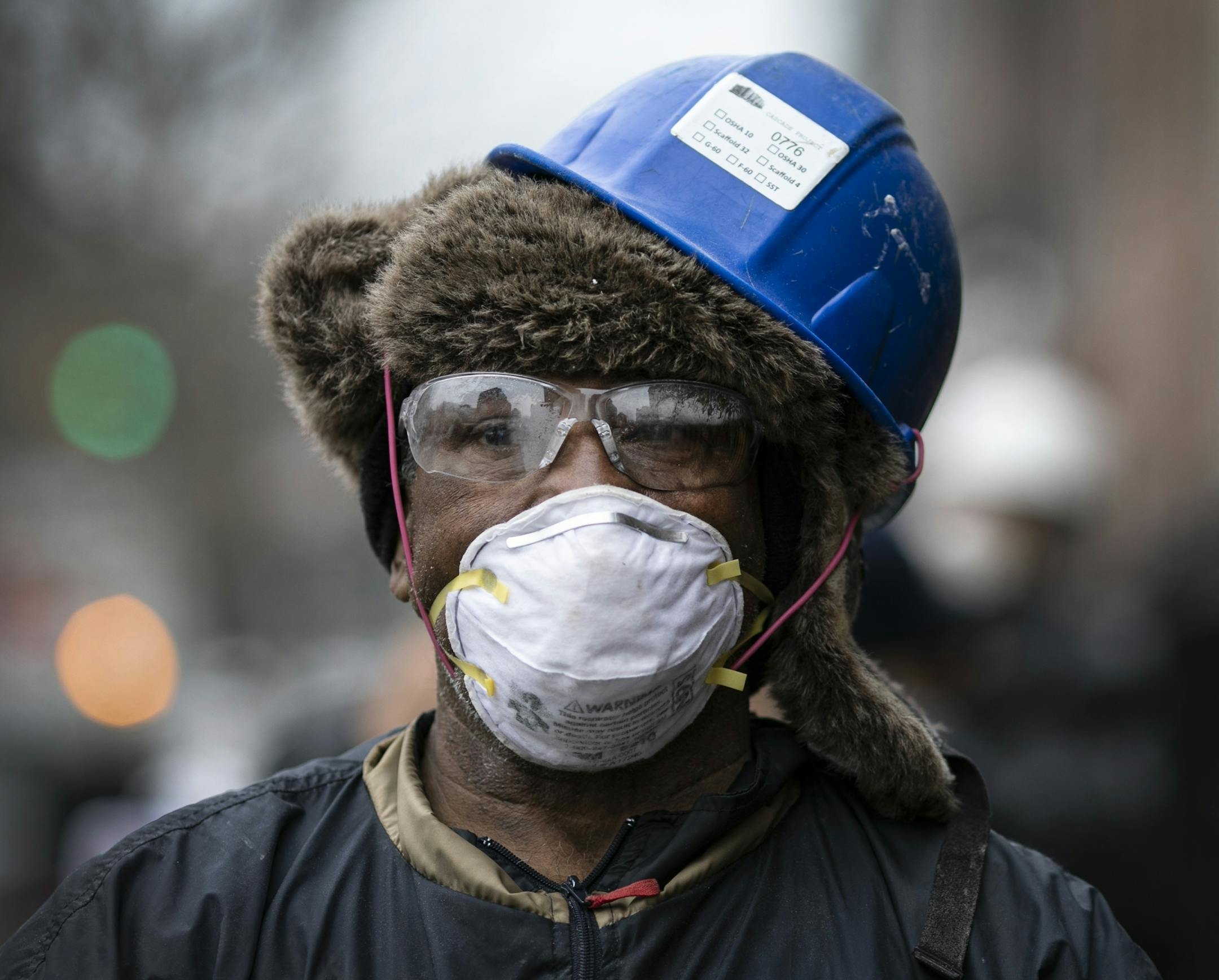 Patricio Francisco, a construction worker, wears protective gear and a face mask as he takes a break from work in the Bedford-Stuyvesant neighborhood of Brooklyn, New York, on Friday, March 20, 2020. New York Gov. Andrew Cuomo is ordering all workers in non-essential businesses to stay home and banning gatherings statewide. Nonessential gatherings of individuals of any size or for any reason are canceled or postponed. (AP Photo/Wong Maye-E)