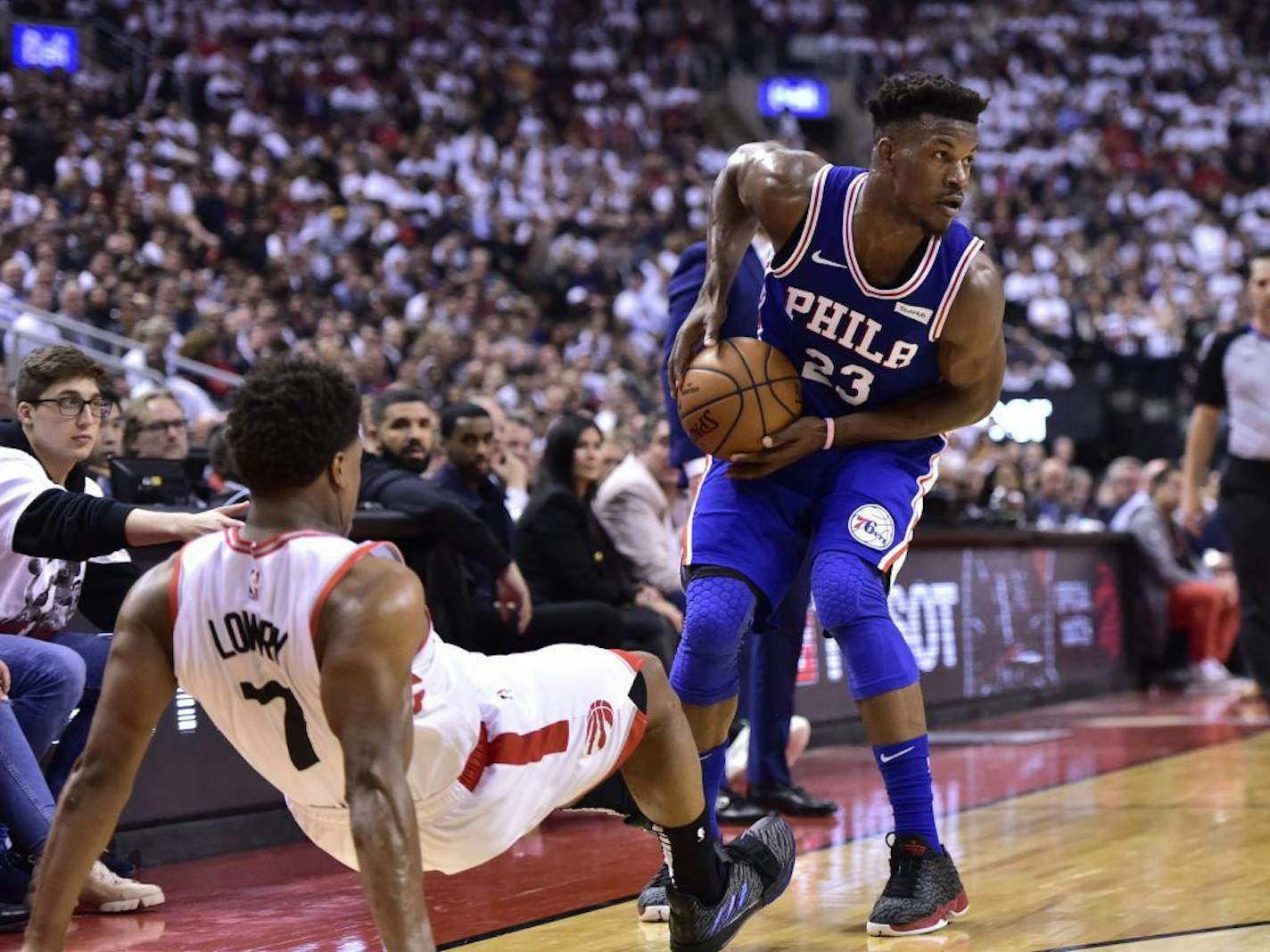 Philadelphia 76ers guard Jimmy Butler (23) looks to pass as Toronto Raptors guard Kyle Lowry (7) falls while defending during first-half, second-round NBA basketball playoff action in Toronto, Monday, April 29, 2019.