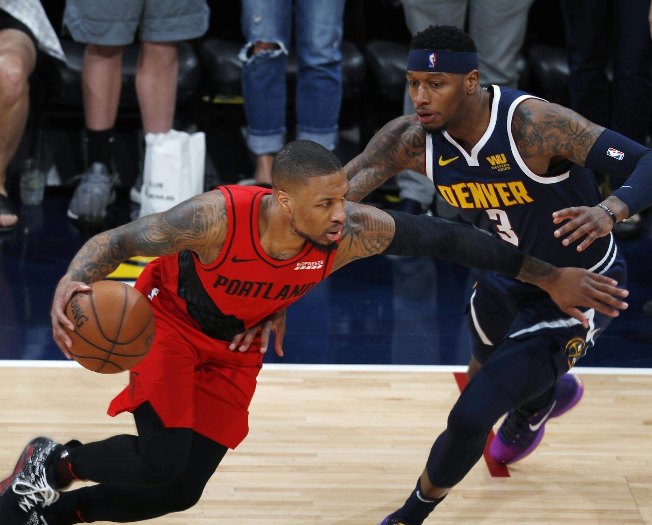 Portland Trail Blazers guard Damian Lillard, left, drives past Denver Nuggets forward Torrey Craig in the first half of Game 7 of an NBA basketball second-round playoff series Sunday, May 12, 2019, in Denver. (AP Photo/David Zalubowski)