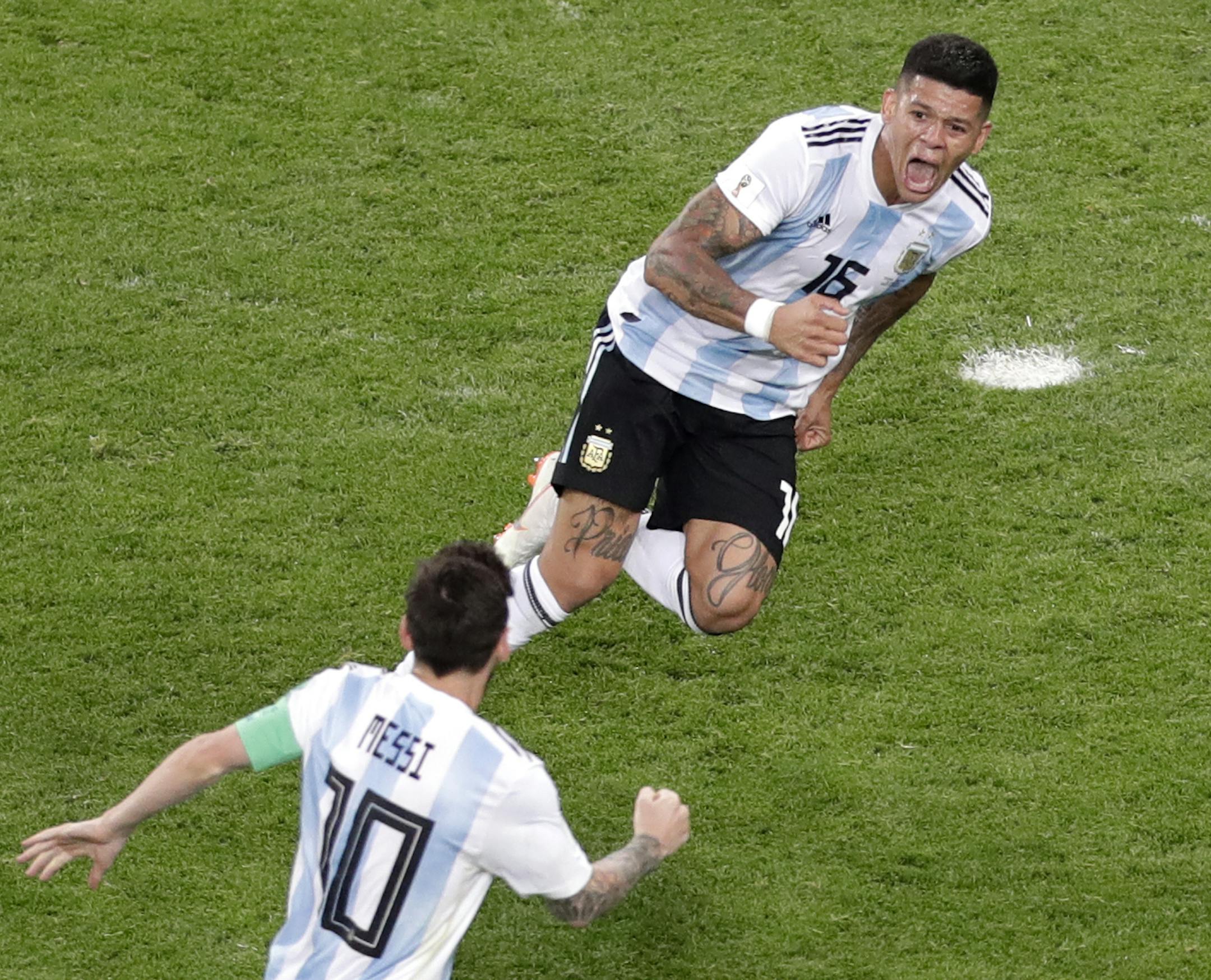 Argentina's Marcos Rojo, top, celebrates with teammate Lionel Messi after scoring his side's second goal during the group D match between Argentina and Nigeria, at the 2018 soccer World Cup in the St. Petersburg Stadium in St. Petersburg, Russia, Tuesday, June 26, 2018. (AP Photo/Michael Sohn)