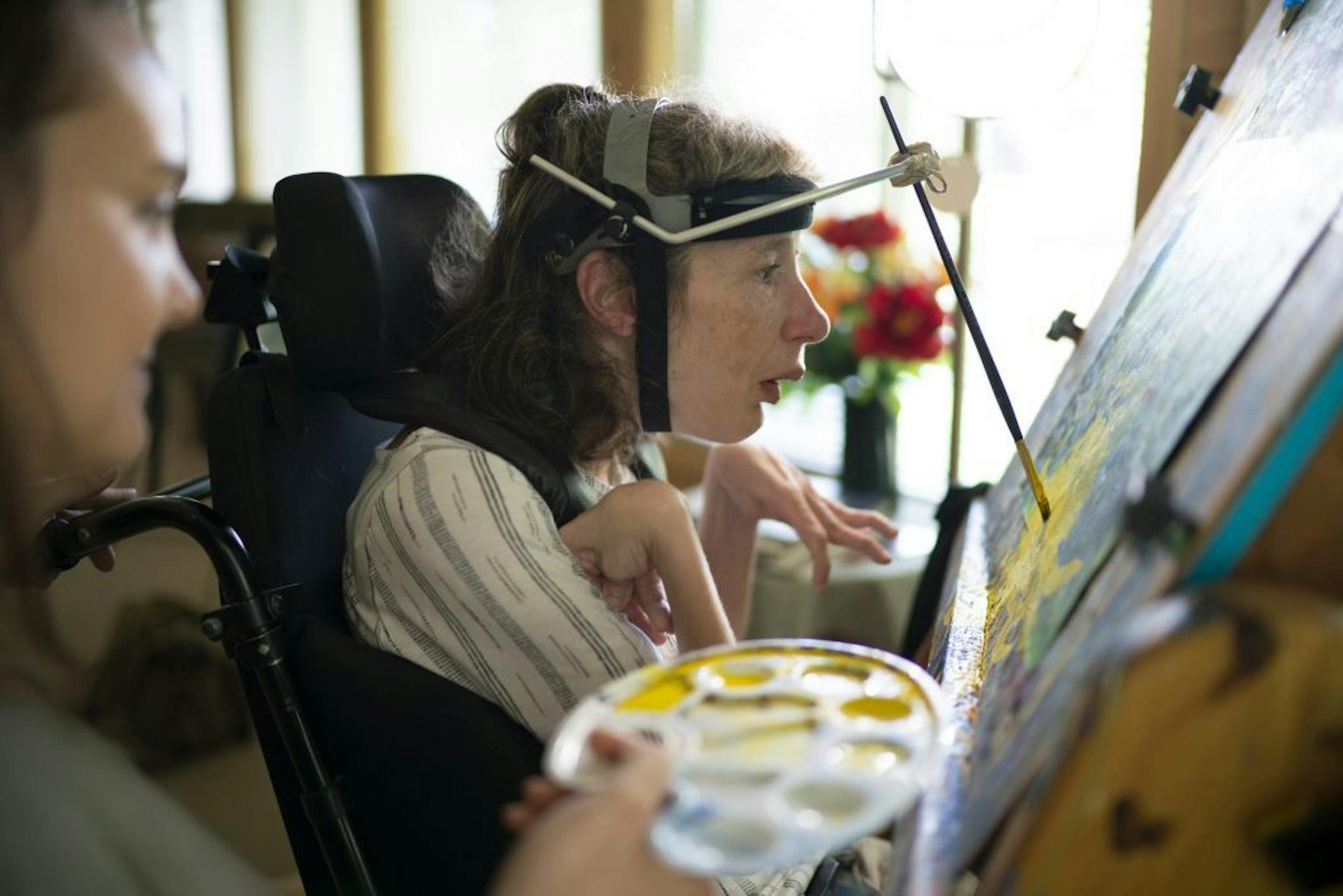 Kari Wagner worked on a painting while her palate was held by Carrie Ingish, a therapeutic recreation specialist with Gillette Children's Specialty Healthcare.
