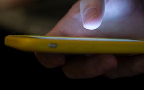 FILE - A man uses a cell phone in New Orleans on Aug. 11, 2019. A number of Americans are dealing with cellular outages on AT&T, Cricket Wireless, Ve