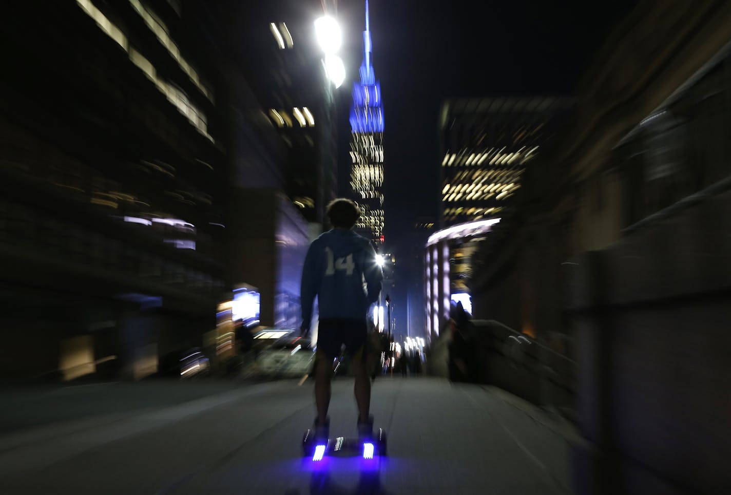 FILE - In this Oct. 21, 2015 file photo, a young man rides a hoverboard down a Manhattan street toward the Empire State Building in New York. The U.S. Consumer Product Safety Commission said the Friday, Feb. 19, 2016 that the hoverboards can be a fire hazard and will go after companies that make, sell, import or distribute hoverboards that don&#xed;t meet safety standards. (AP Photo/Kathy Willens)