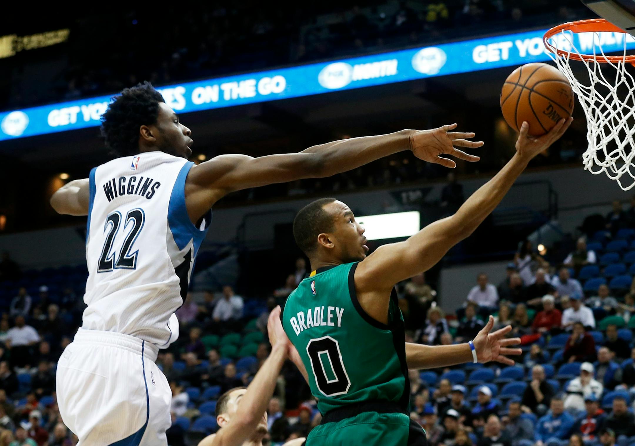 Minnesota Timberwolves' Andrew Wiggins, left, reaches in vain for the ball as Boston Celtics' Avery Bradley lays up a shot during the first quarter of an NBA basketball game Monday, Feb. 22, 2016, in Minneapolis.