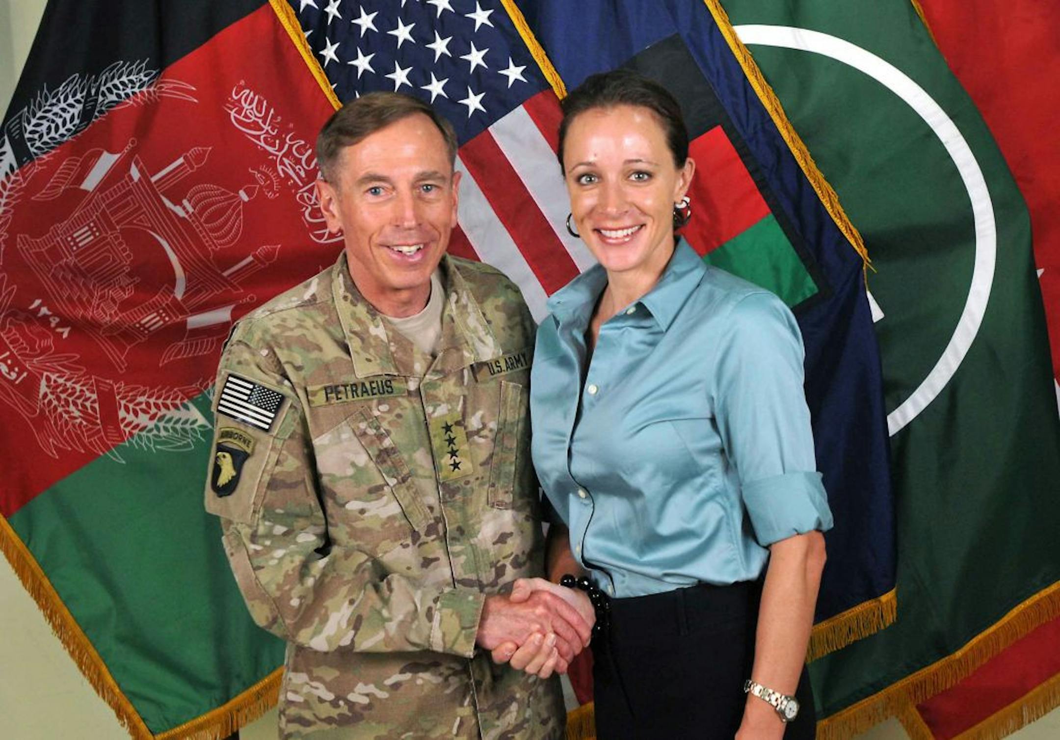 FILE - This July 13, 2011, photo made available on the International Security Assistance Force's Flickr website shows the former Commander of International Security Assistance Force and U.S. Forces-Afghanistan Gen. Davis Petraeus, left, shaking hands with Paula Broadwell, co-author of his biography "All In: The Education of General David Petraeus." The affair between retired Army Gen. David Patraeus and author Paula Broadwell is but an extreme example of the love/hate history between biographers