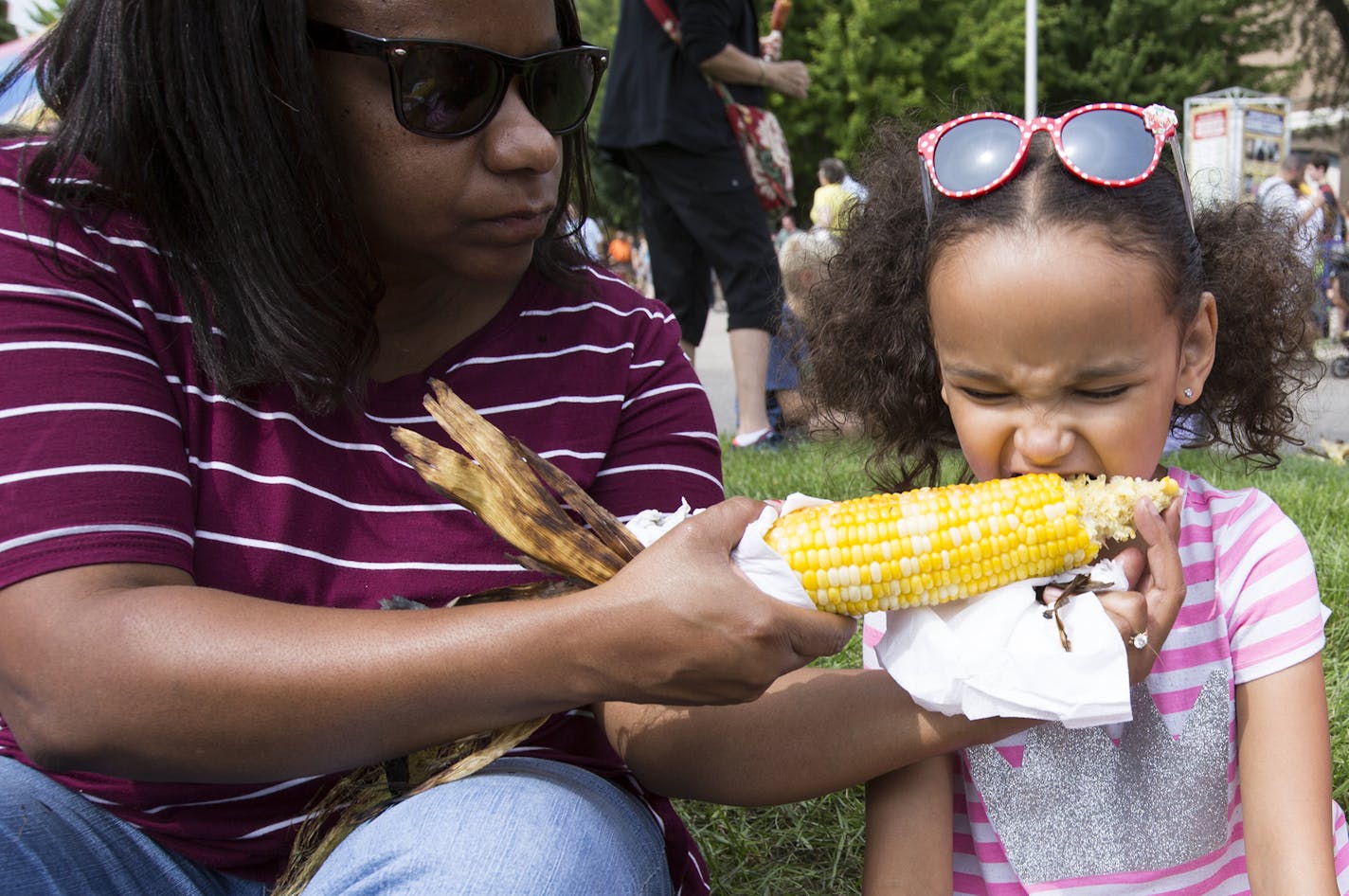 Diane Thoemke of Coon Rapids feeds her daughter Peyton, 6, roasted corn as dad Steve looks on. ] (Leila Navidi/Star Tribune) leila.navidi@startribune.com BACKGROUND INFORMATION: Food at the Minnesota State Fair on Thursday, August 25, 2016. Rick Nelson reviews the new food this year.