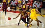 Minnesota's Marcus Carr, front left, splits the defense against Maryland during the first half of an NCAA college basketball game, Sunday, Feb. 14, 20