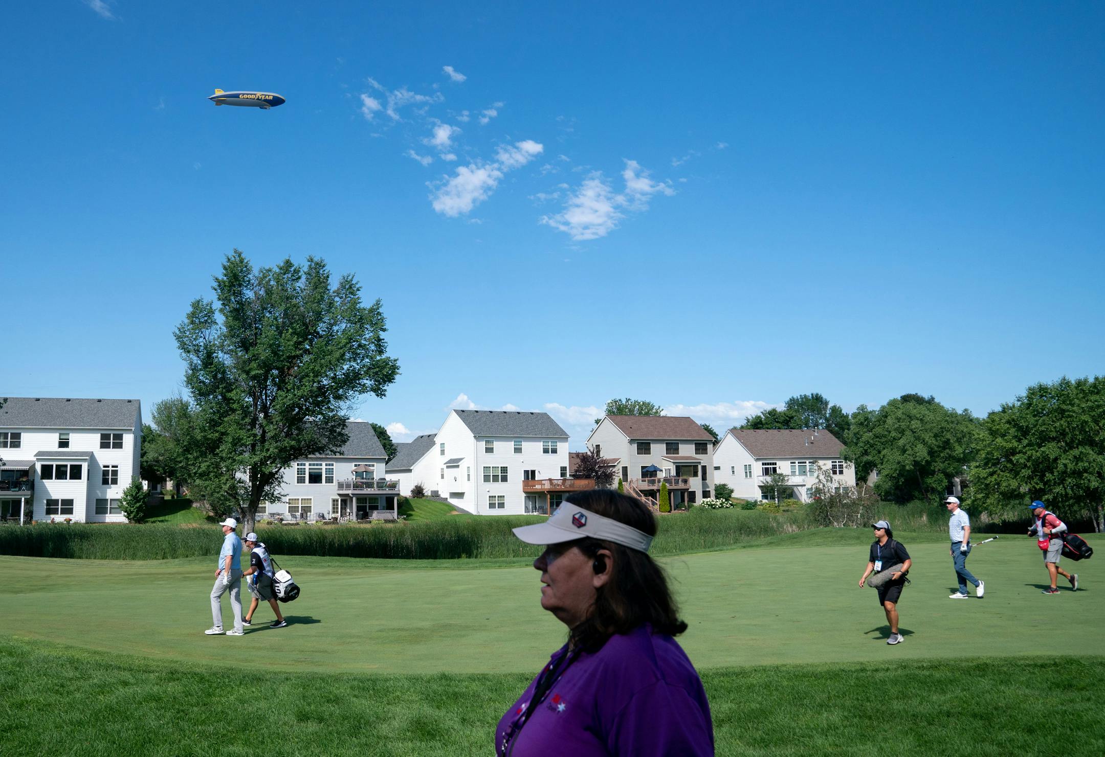 A Goodyear Blimp flies over the ninth hole during the 3M Open.