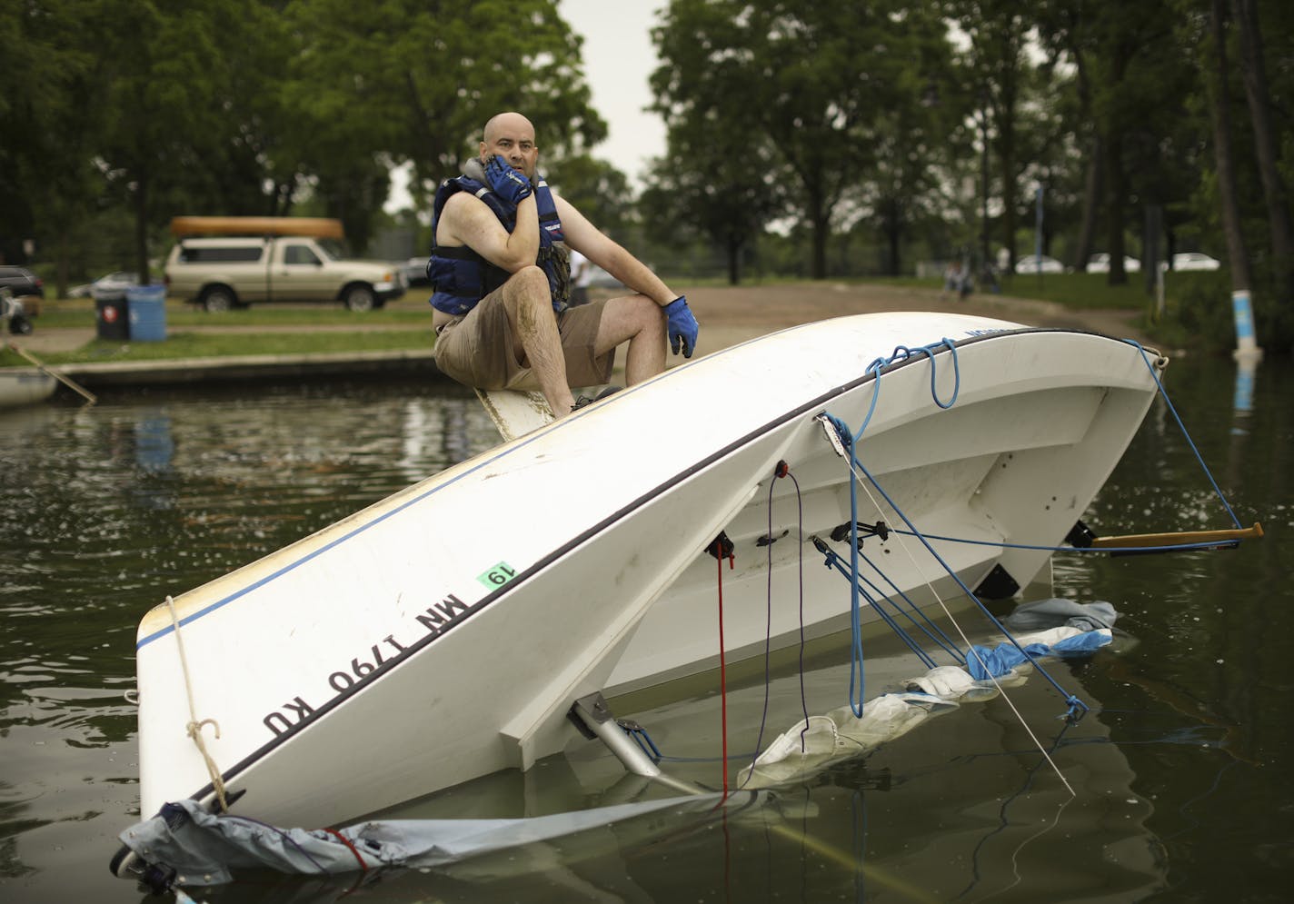 Martin Conroy waited for some help from others as he attempted to right his overturned sailboat on Lake Nokomis Sunday afternoon. When he drove past the lake after the storm Sunday morning, "I saw that I was the only one flipped, so I went home and changed for my unplanned afternoon adventure." ] JEFF WHEELER &#xef; jeff.wheeler@startribune.com High winds and rain hit the metro area hard Sunday morning, June 11, 2017, downing trees and knocking out power in some areas.