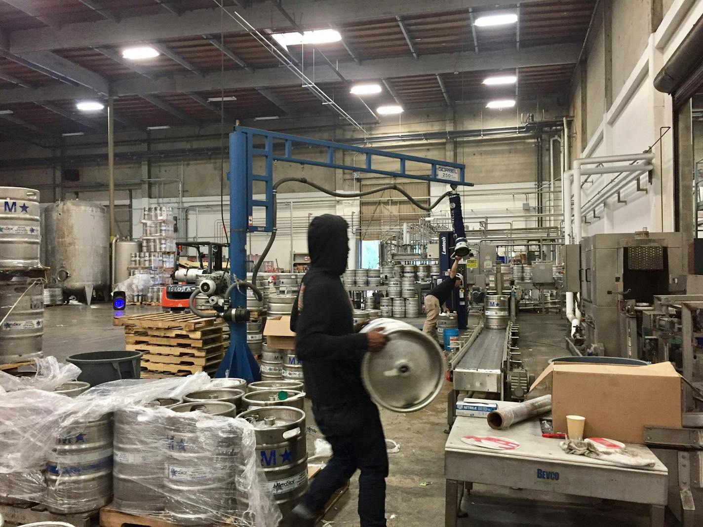 Crews cleaned empty kegs and loaded up full kegs at Ballast Point Brewing at its Miramar taproom in San Diego.