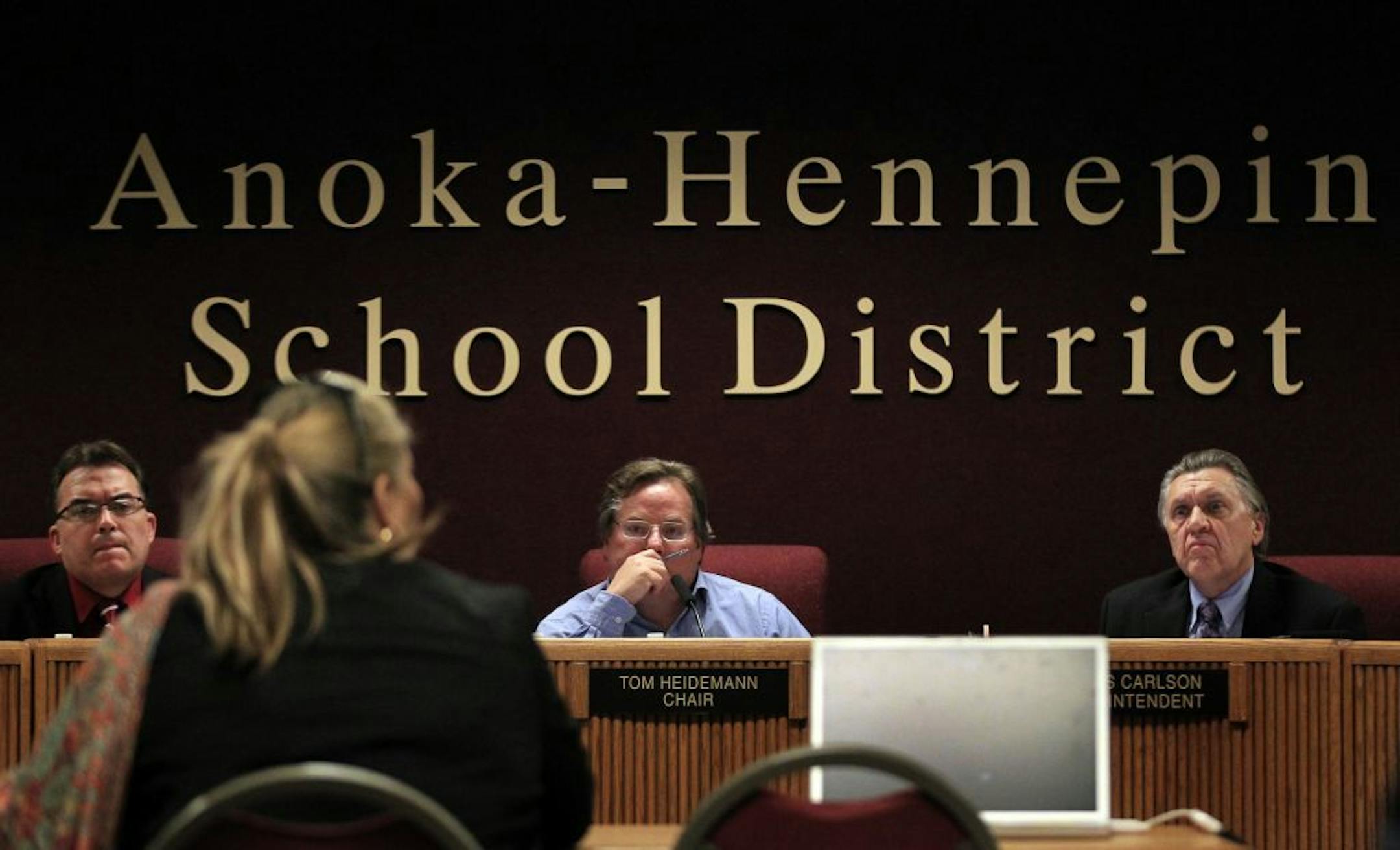 John Hoffman, Vice Chair, Tom Heidemann, Chair, and Dennis Carlson, Superintendent of the Anoka-Hennepin School Board listened to Pastor Barb White of Minneapolis during a meeting on Monday night.