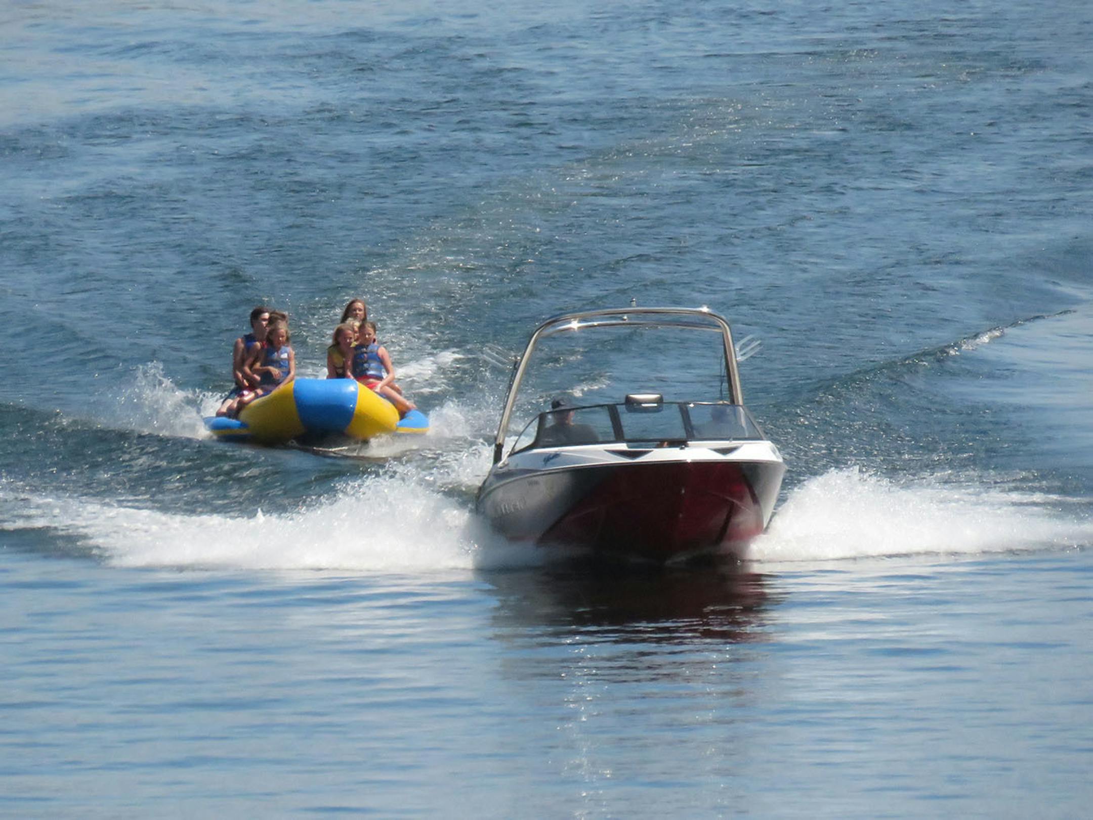 About a dozen kids pile onto Madden's "banana taxi" for the popular shriek-worthy spin around the lake and skip across the waves.