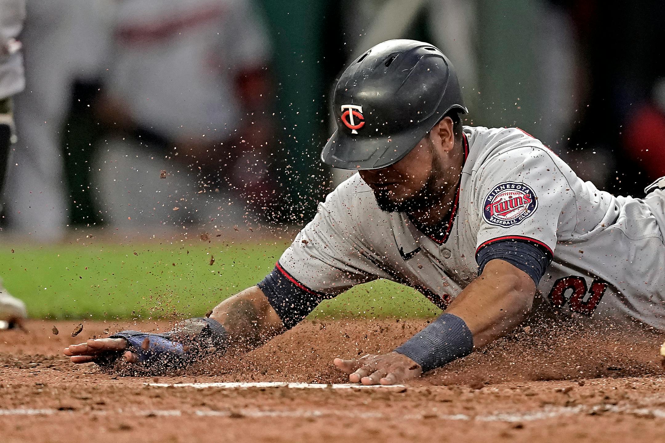 Minnesota Twins' Luis Arraez slides home to score on a wild pitch by Kansas City Royals relief pitcher Gabe Speier during the eighth inning of a baseball game Saturday, May 21, 2022, in Kansas City, Mo. (AP Photo/Charlie Riedel)