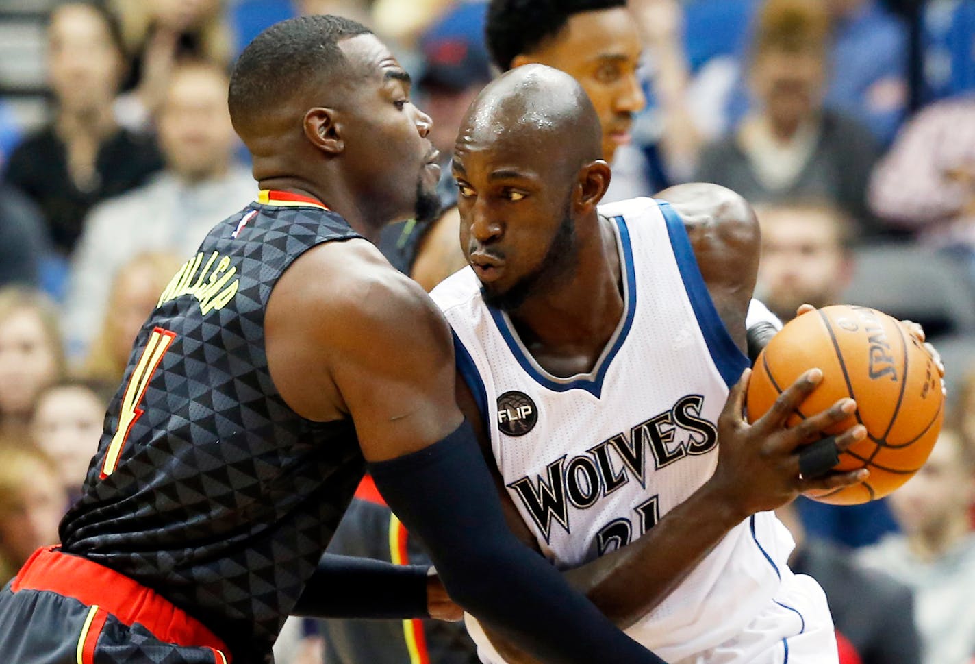 FILE - In this Nov. 25, 2015, file photo, Minnesota Timberwolves' Kevin Garnett, right, drives on Atlanta Hawks' Paul Millsap.