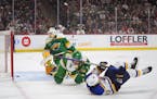 Wild goalie Marc-Andre Fleury watches the puck slide out of the net after a goal by Blues left wing Jake Neighbours, front, during the first period Sa