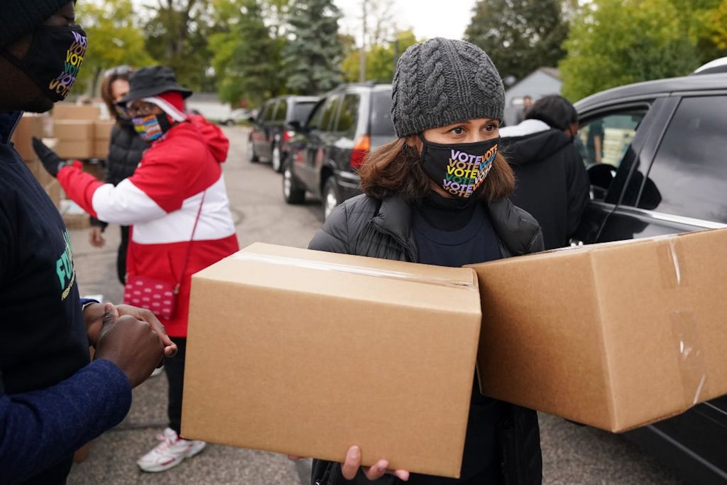 Reba Dominski carried boxes of food and supplies to awaiting cars during a "Fuel the Vote" event Saturday.