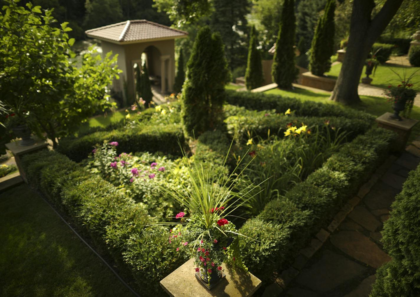 A parterre, or knot garden in Brian Ellingson's terraced backyard. ] JEFF WHEELER &#x2022; jeff.wheeler@startribune.com Edina interior designer Brian Ellingson has created a very formal, structured backyard garden featuring dramatic structural elements and hardscaping, including fountains, statues, and brick paths. He and his garden were photographed Thursday afternoon, August 2, 2018 in Edina.