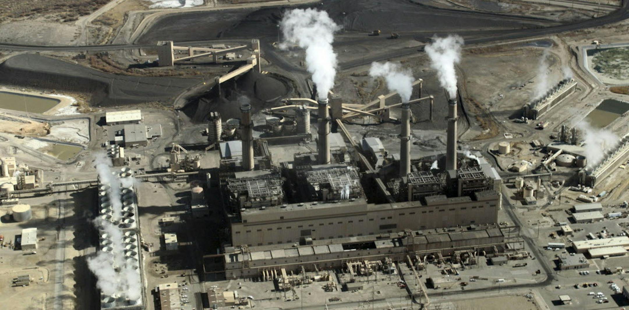 FILE - This Nov. 9, 2009, file photo, shows the coal-fired San Juan Generating Station near Farmington, N.M. State regulators are considering a plan by Public Service Co. of New Mexico to close two units at the power plant and replace the power with a mix of coal, nuclear, natural gas and solar energy. (AP Photo/Susan Montoya Bryan, File)