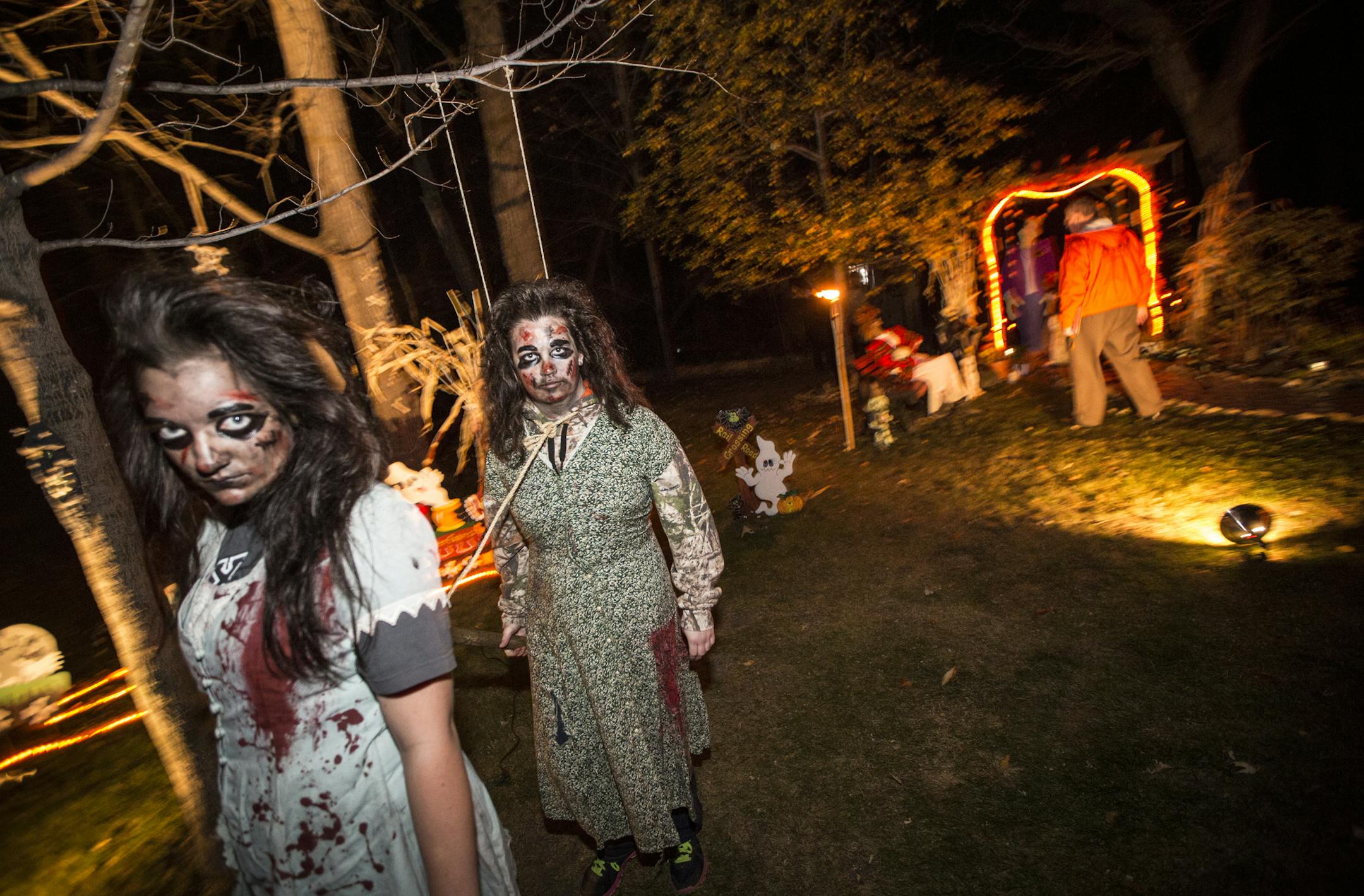 Kelsey Haggard and Sarah Koester walked around in a zombie state dragging a sledge hammer as part of the Orchid Street NW, Andover, Minn., Halloween scene on Wednesday, October 22, 2014. This scene won first place. Fourteen families are competing in the city of Anoka's annual Halloween outdoor decorating contest. ] RENEE JONES SCHNEIDER &#x2022; reneejones@startribune.com