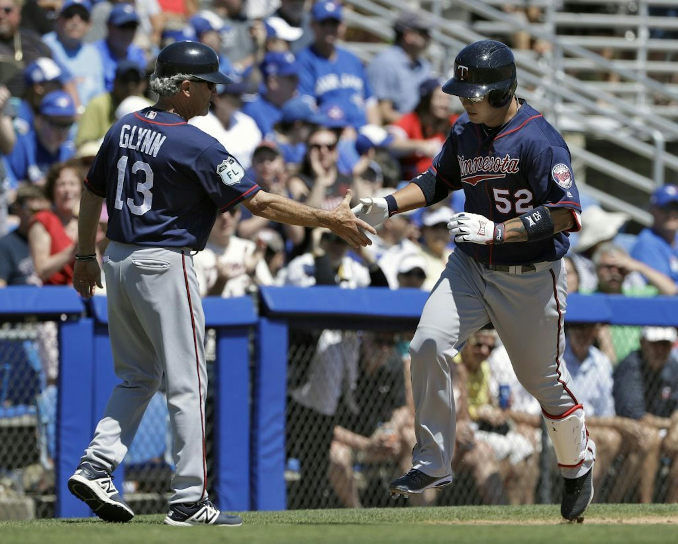 Minnesota Twins' Byung Ho Park (52) shakes hands with third base coach Gene Glynn after Park hit a two-run home run off Toronto Blue Jays starting pitcher Francisco Liriano during the fifth inning of a spring training baseball game Monday, March 20, 2017, in Dunedin, Fla.