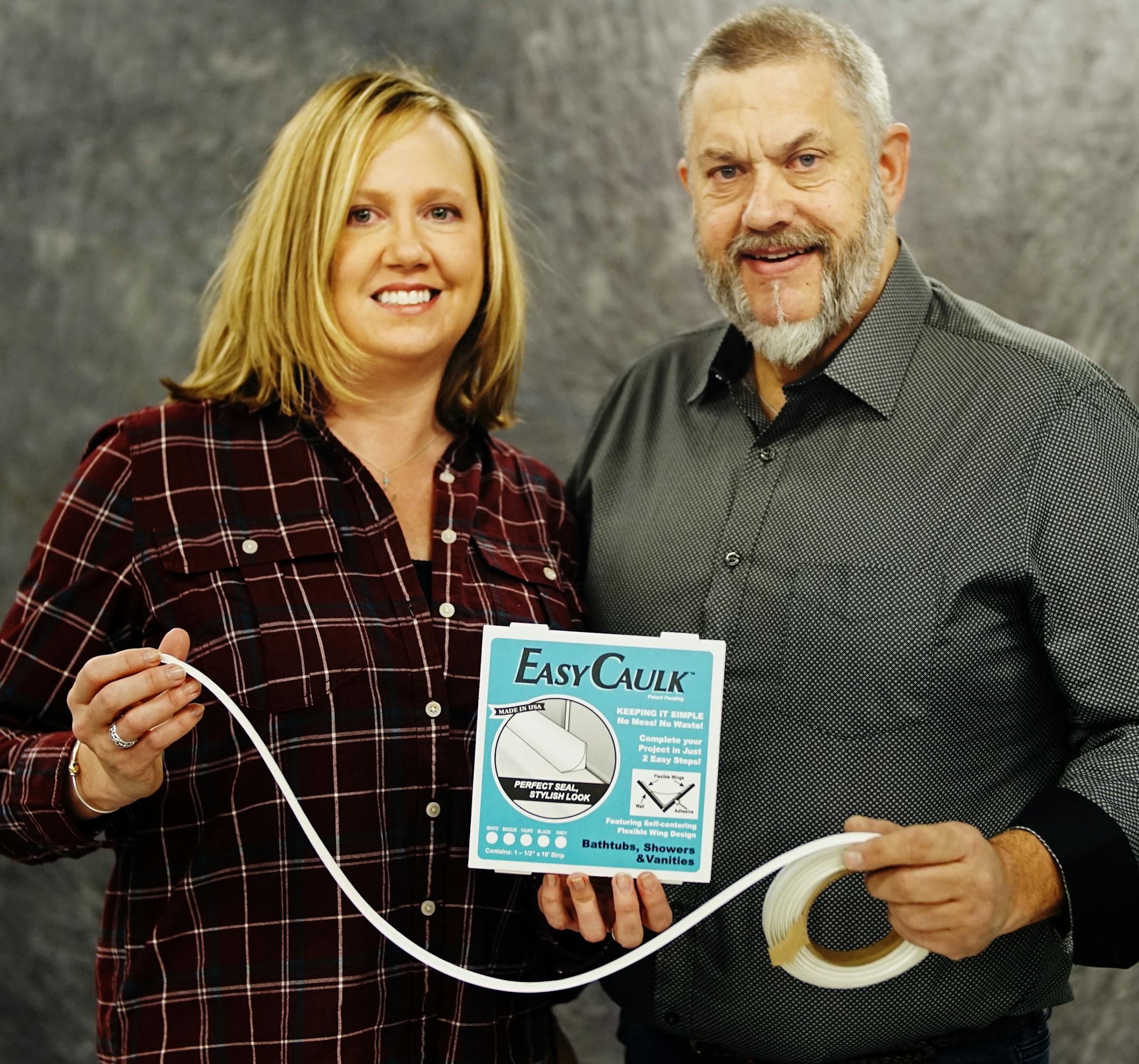 Betsy Berge and Greg Admundson with the press-in-place caulk strip that Amundson devised. He thought of the idea during a bout of insomnia.