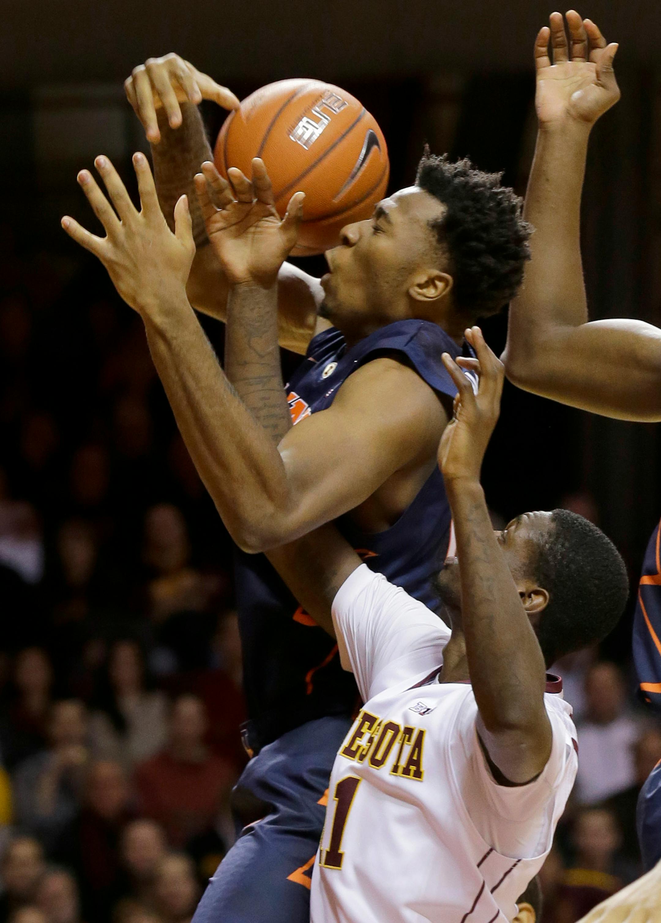 Illinois forward Leron Black, top, pulls down a rebound over Minnesota guard Carlos Morris, bottom, during the first half of an NCAA college basketball game in Minneapolis, Saturday, Jan. 24, 2015. (AP Photo/Ann Heisenfelt)