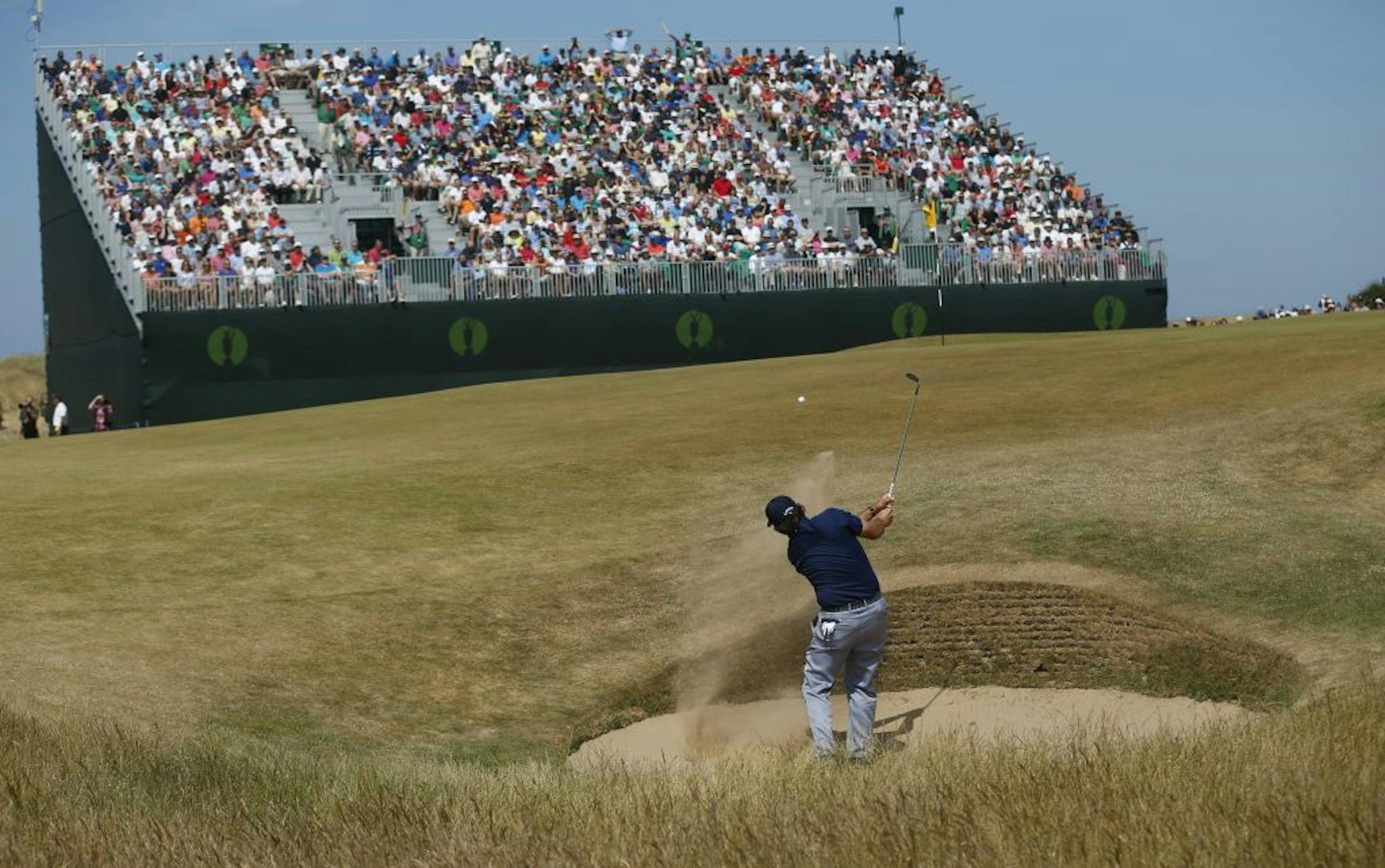 Phil Mickelson of the United States plays out of a bunker onto the 4th green during the third round of the British Open Golf Championship at Muirfield, Scotland, Saturday July 20, 2013.